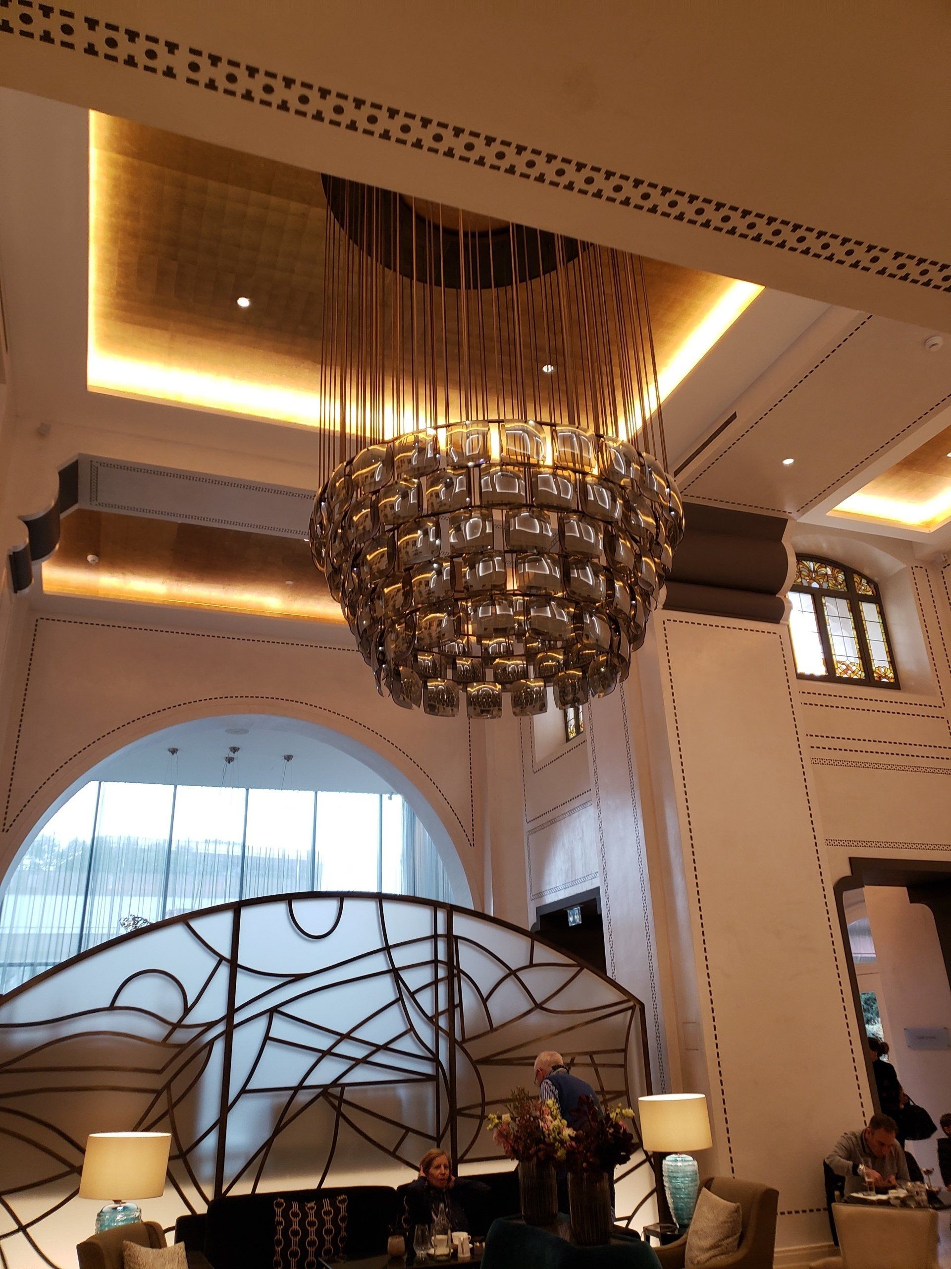 A large chandelier hangs from the ceiling of a room