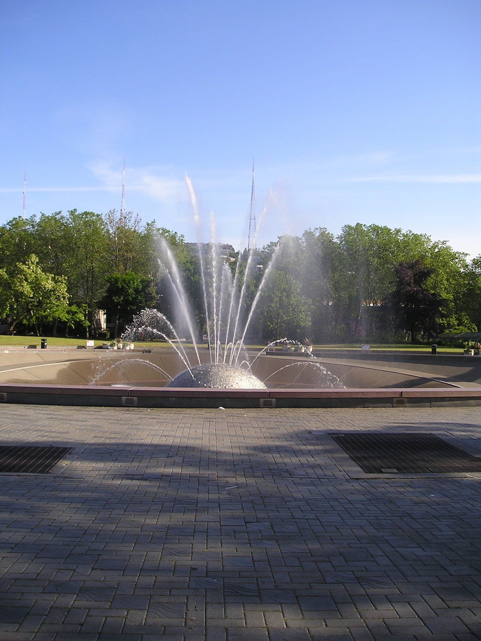 A fountain in a park with trees in the background