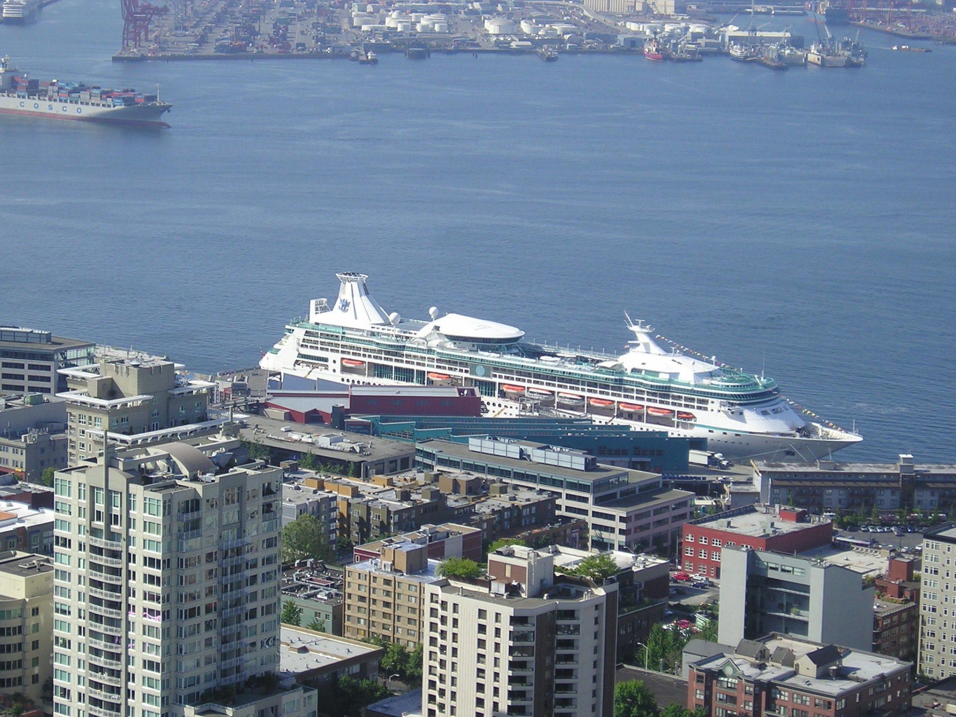 An aerial view of a city with a cruise ship in the water