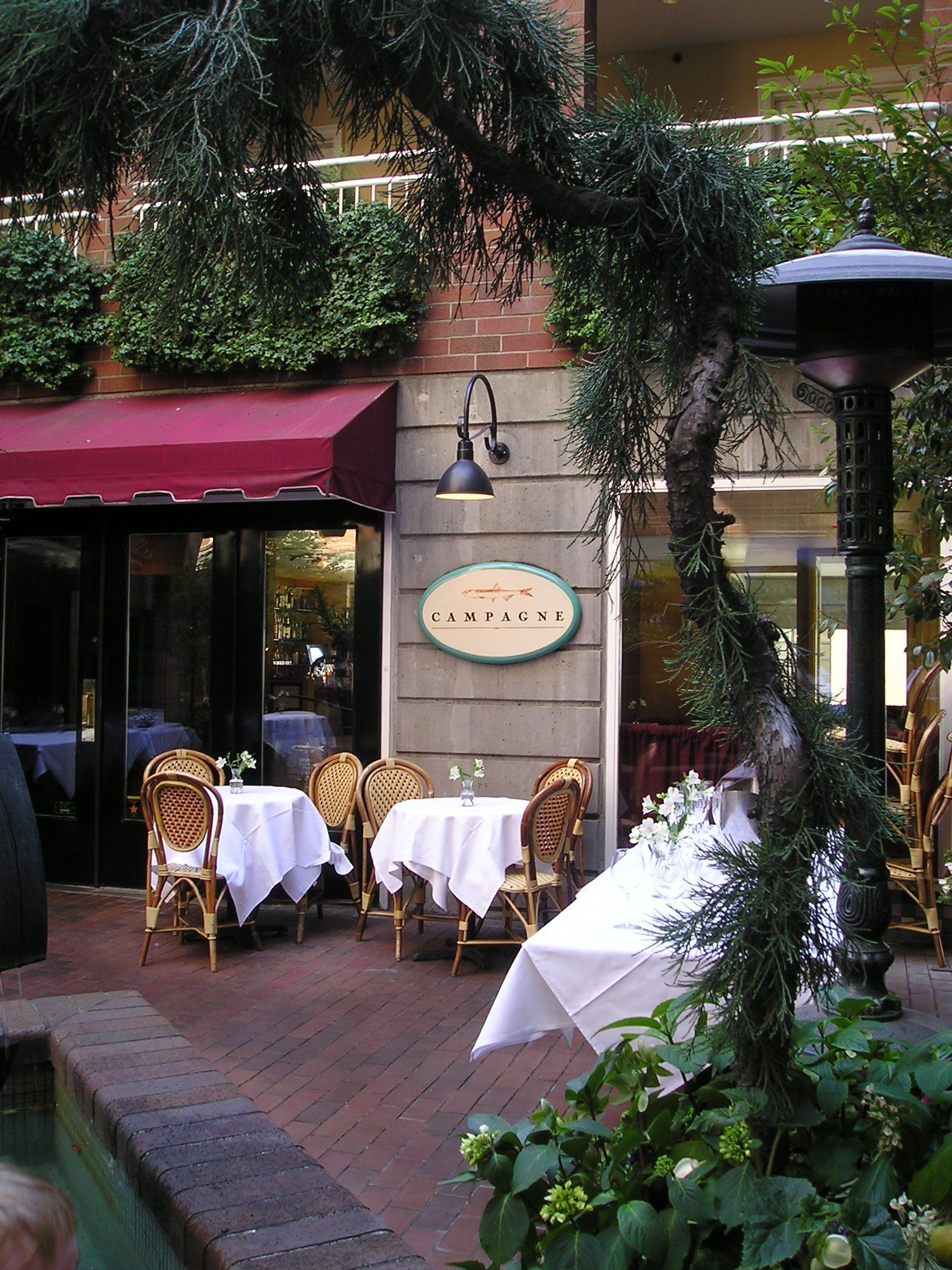 A restaurant with tables and chairs outside and a sign that says ' a ' on it