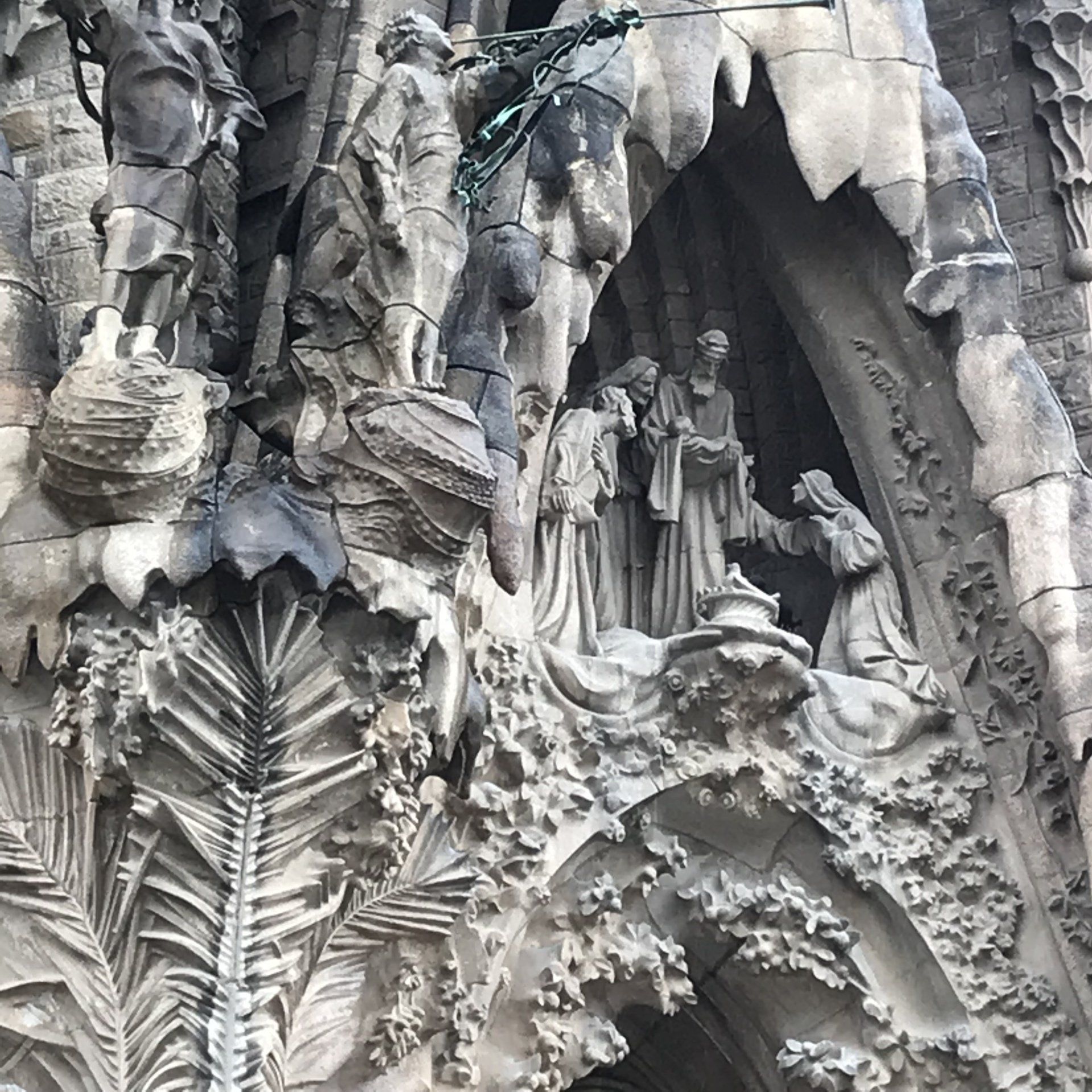 A close up of a statue on the side of a building.