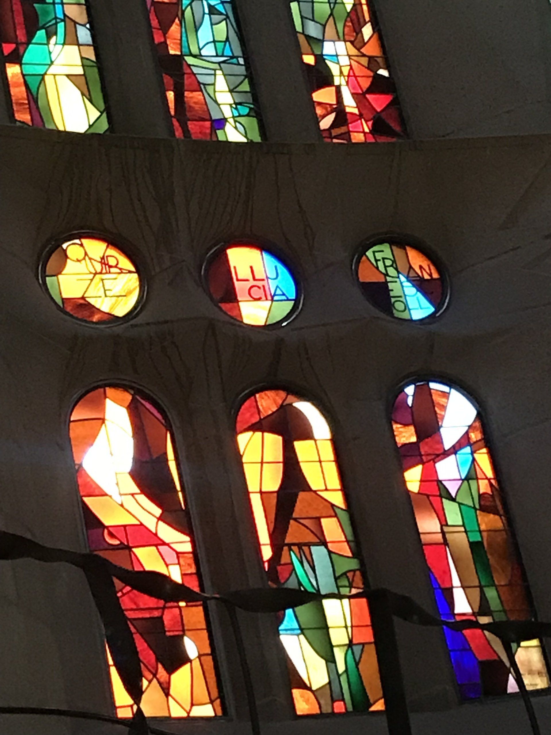 A stained glass window in a church with the word jesus on it