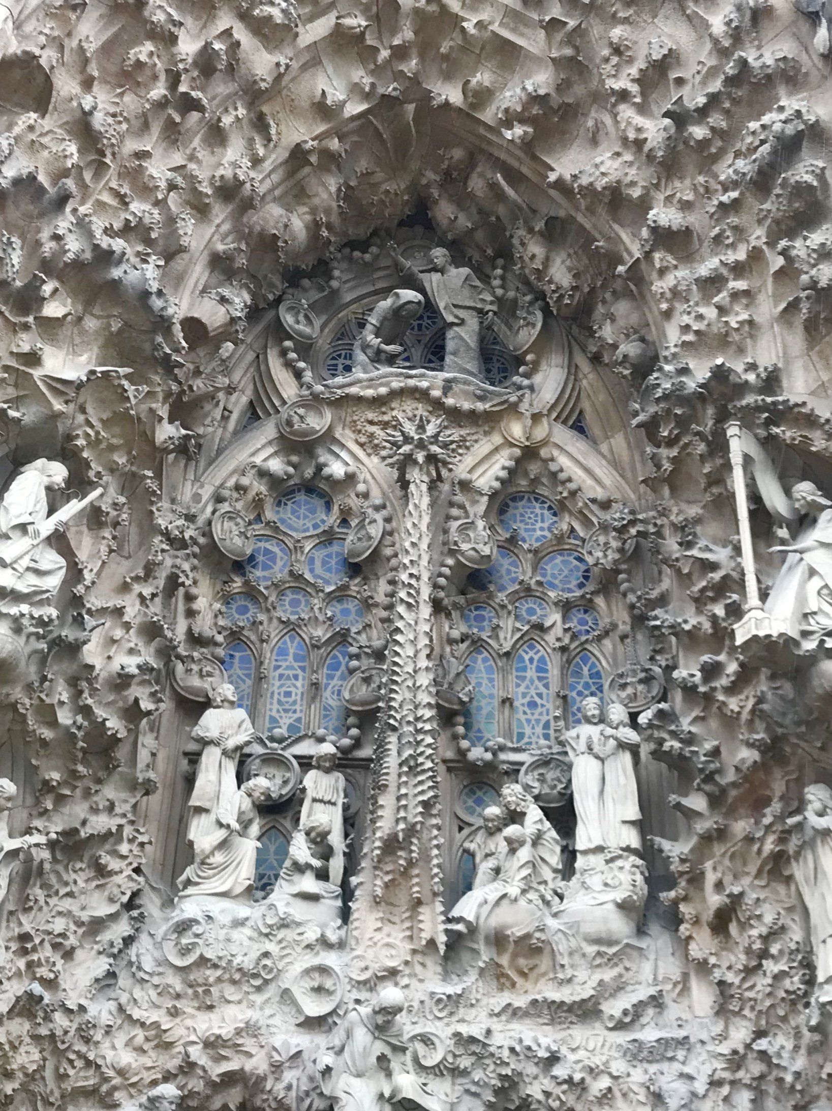 A close up of a statue on the side of a building.