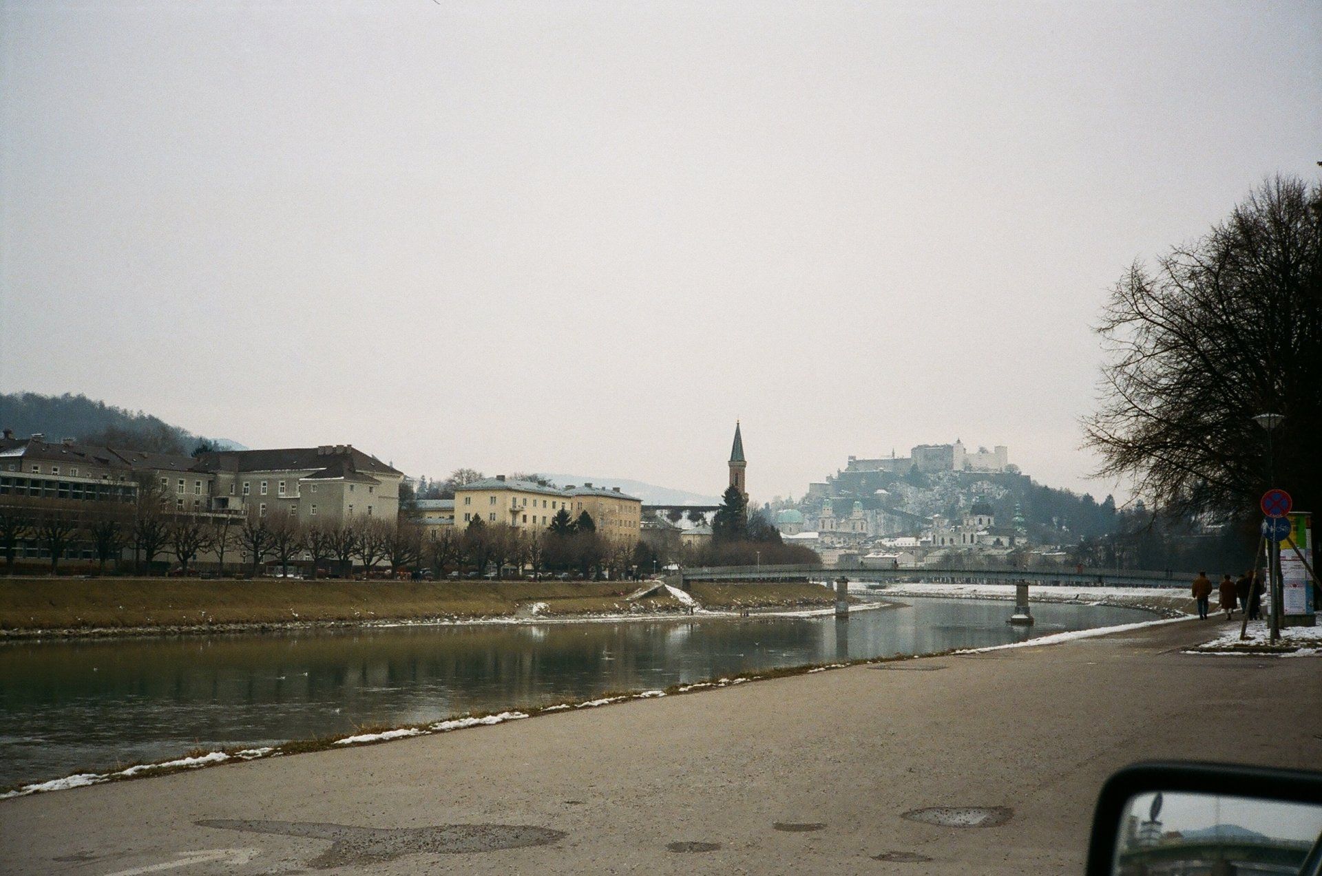 A view of a city from a car window with a river in the foreground