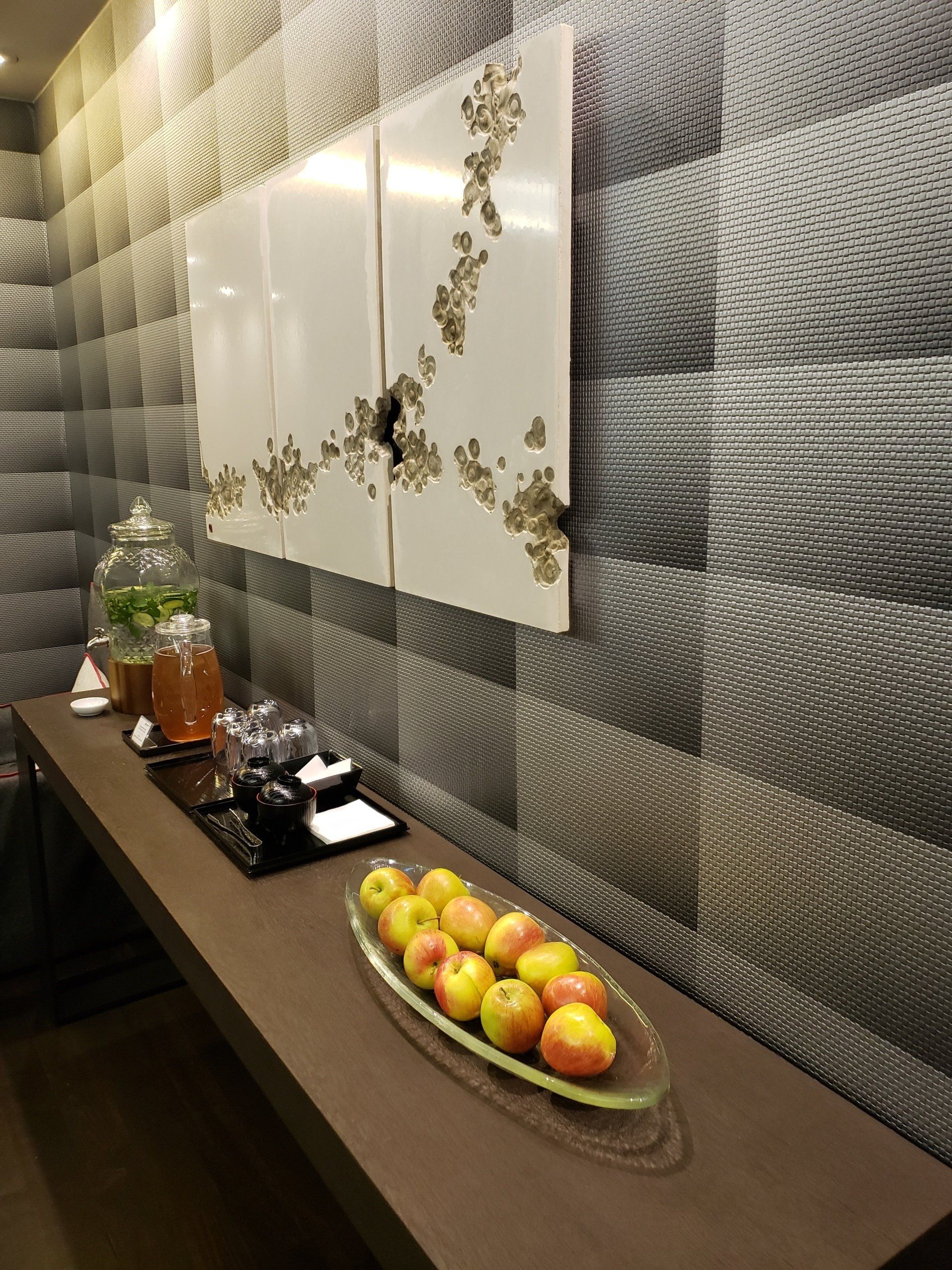 A table with a bowl of apples on it