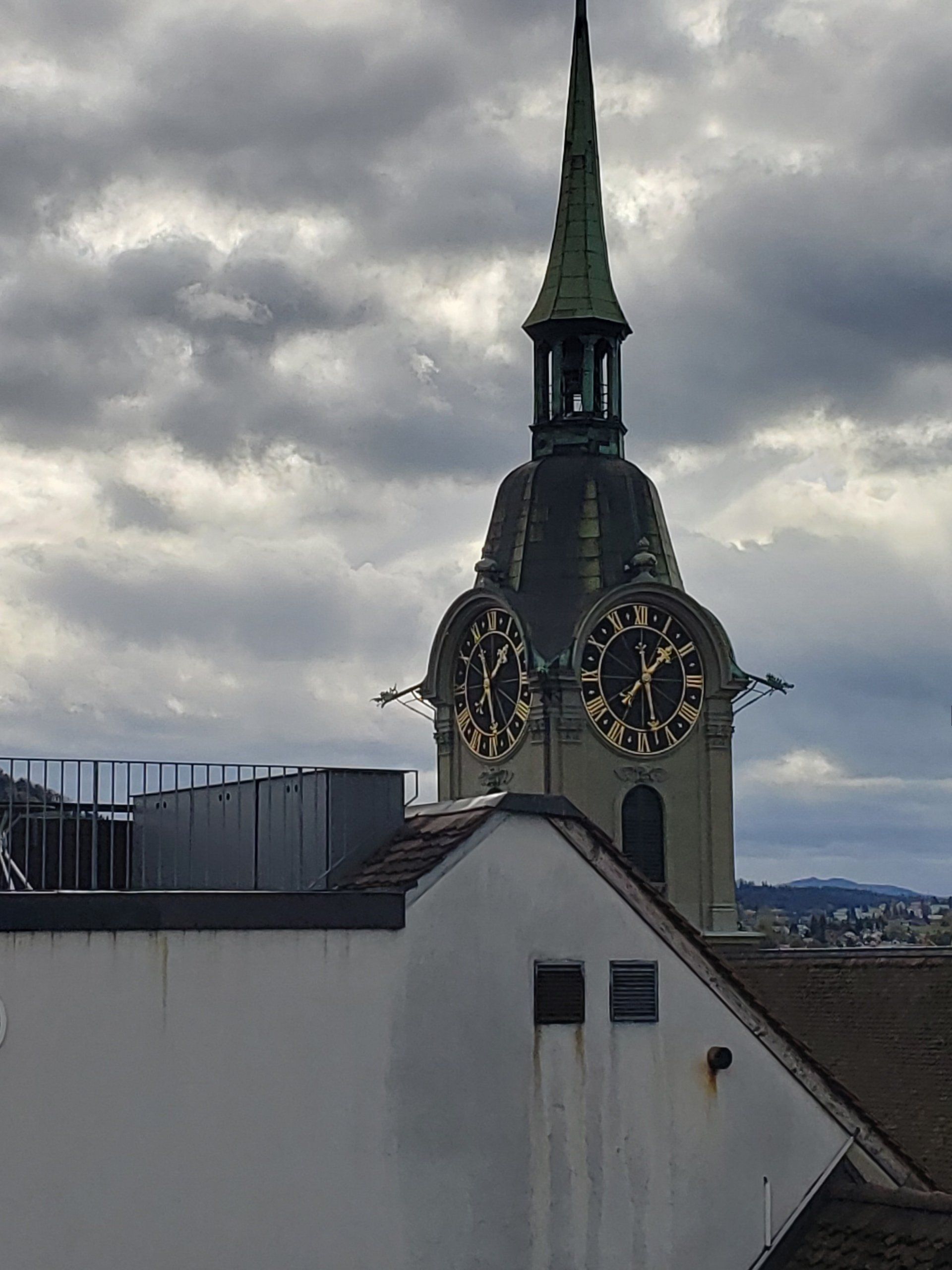 A clock tower on top of a building with a cloudy sky in the background.