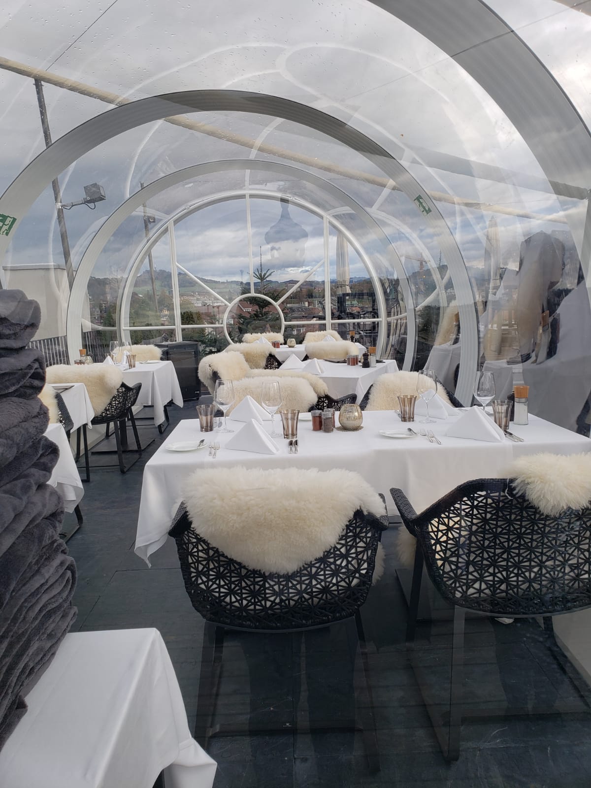 A restaurant with tables and chairs under a clear dome.