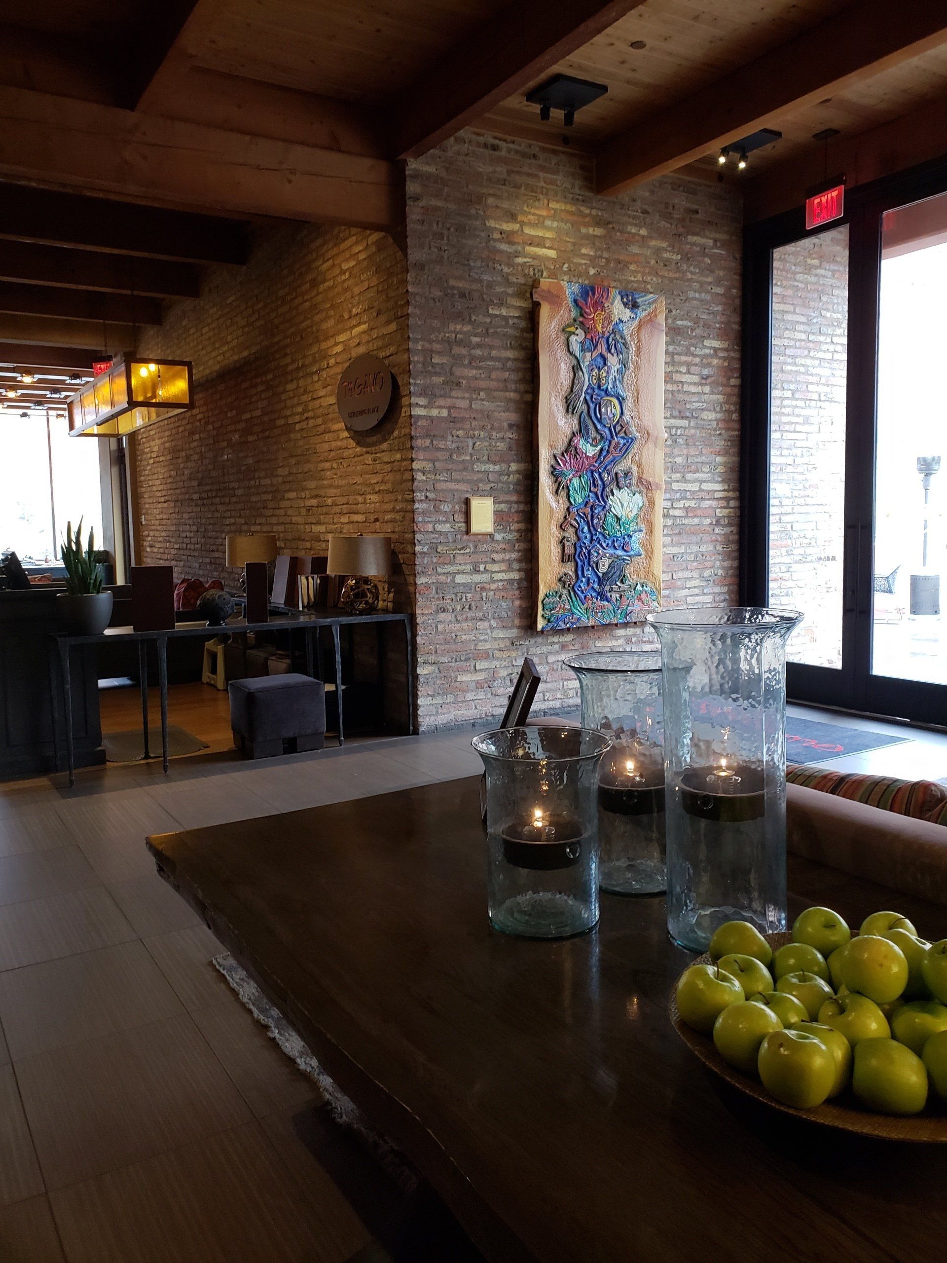 A table with a bowl of apples and candles on it