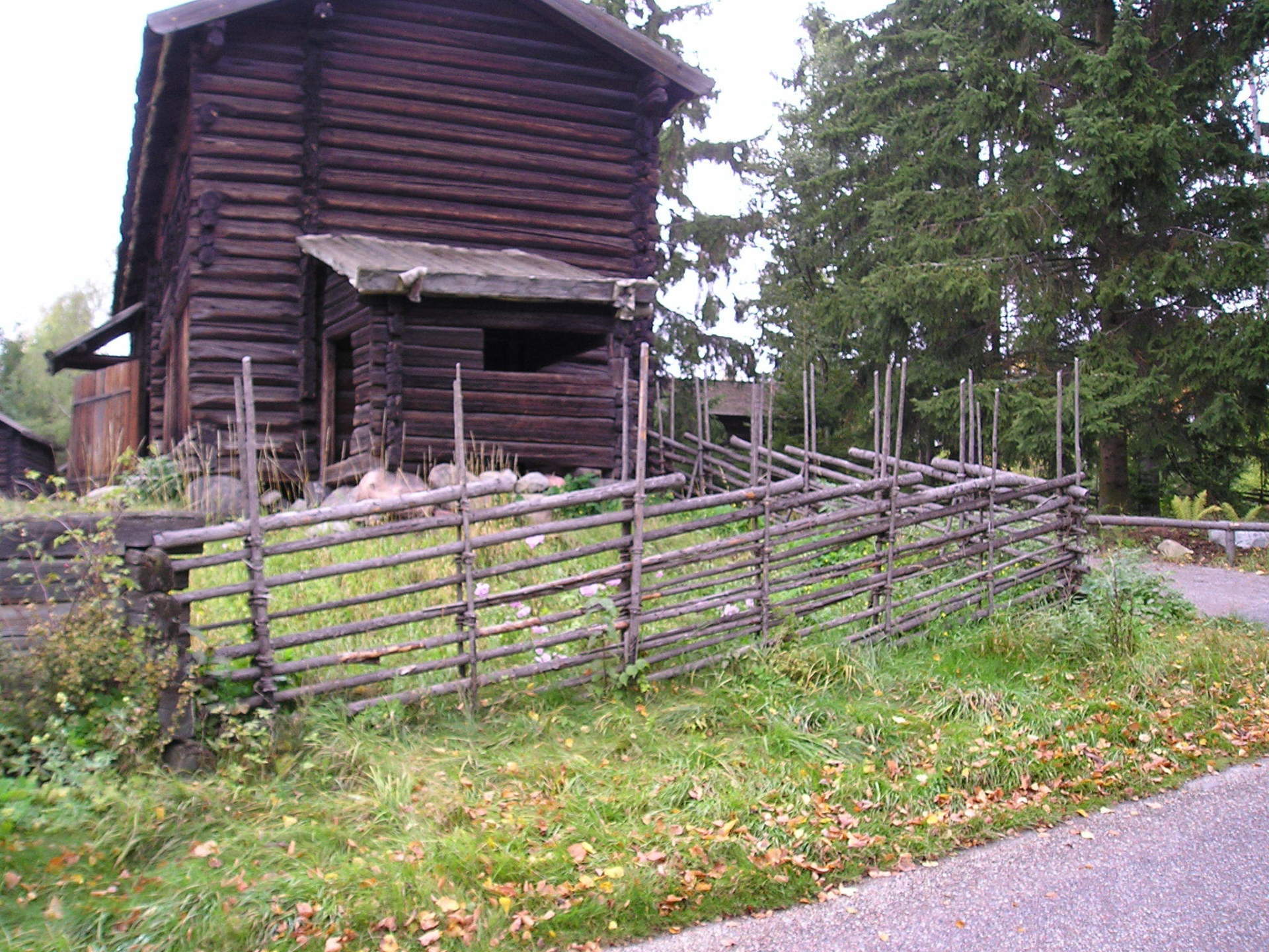 A wooden fence is in front of a wooden house
