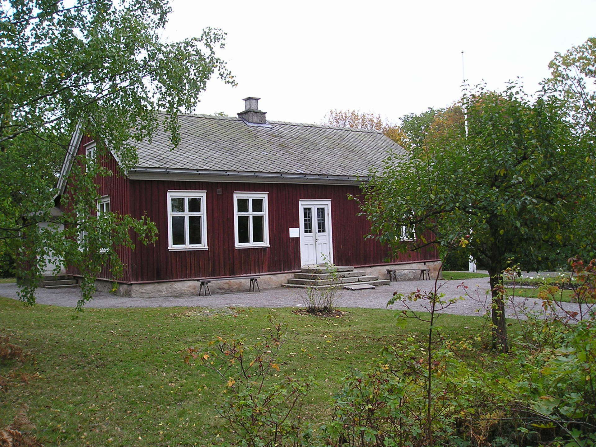 A red house with white windows and a white door