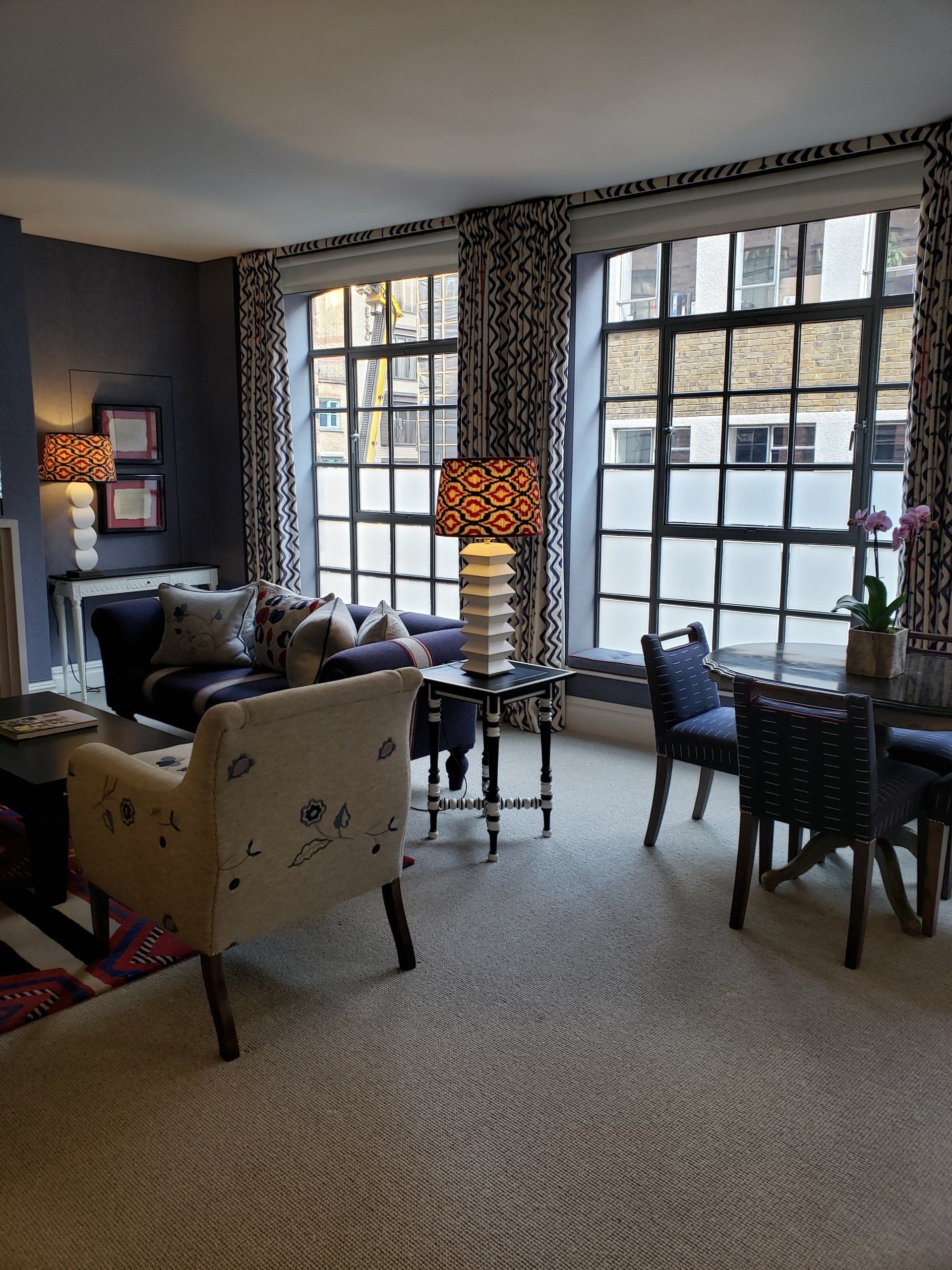 A living room with a couch a chair a table and a lamp