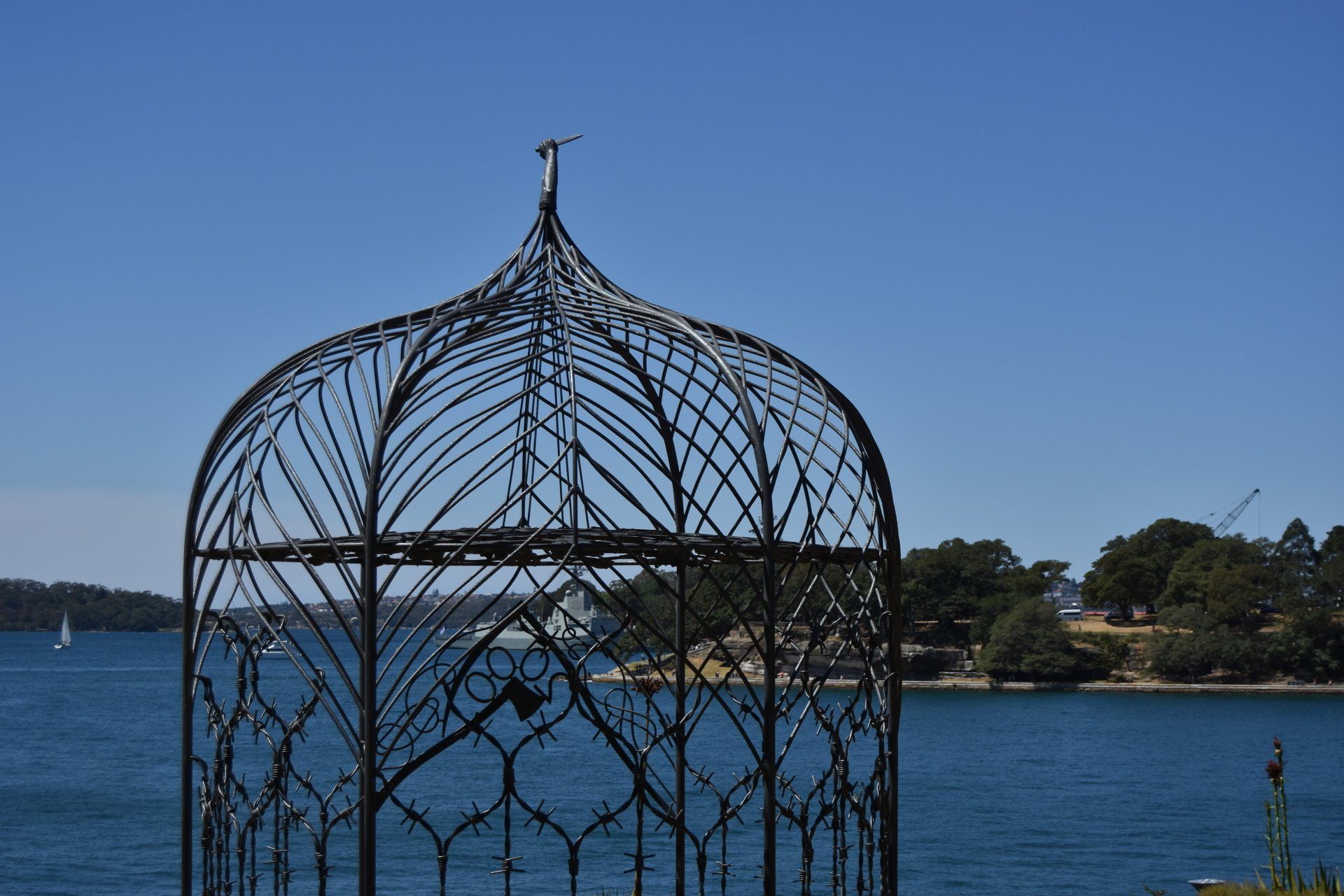 A wrought iron gazebo overlooking a body of water