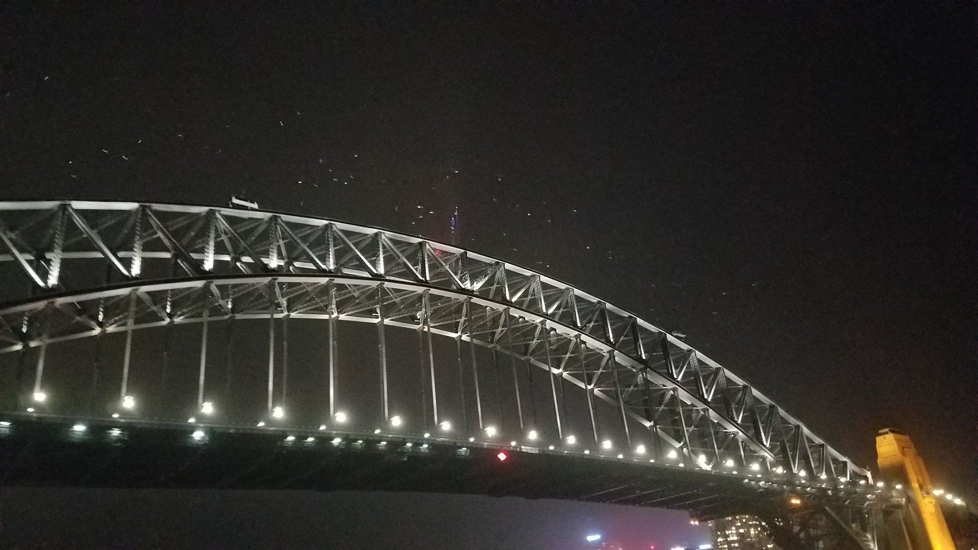 The sydney harbor bridge is lit up at night
