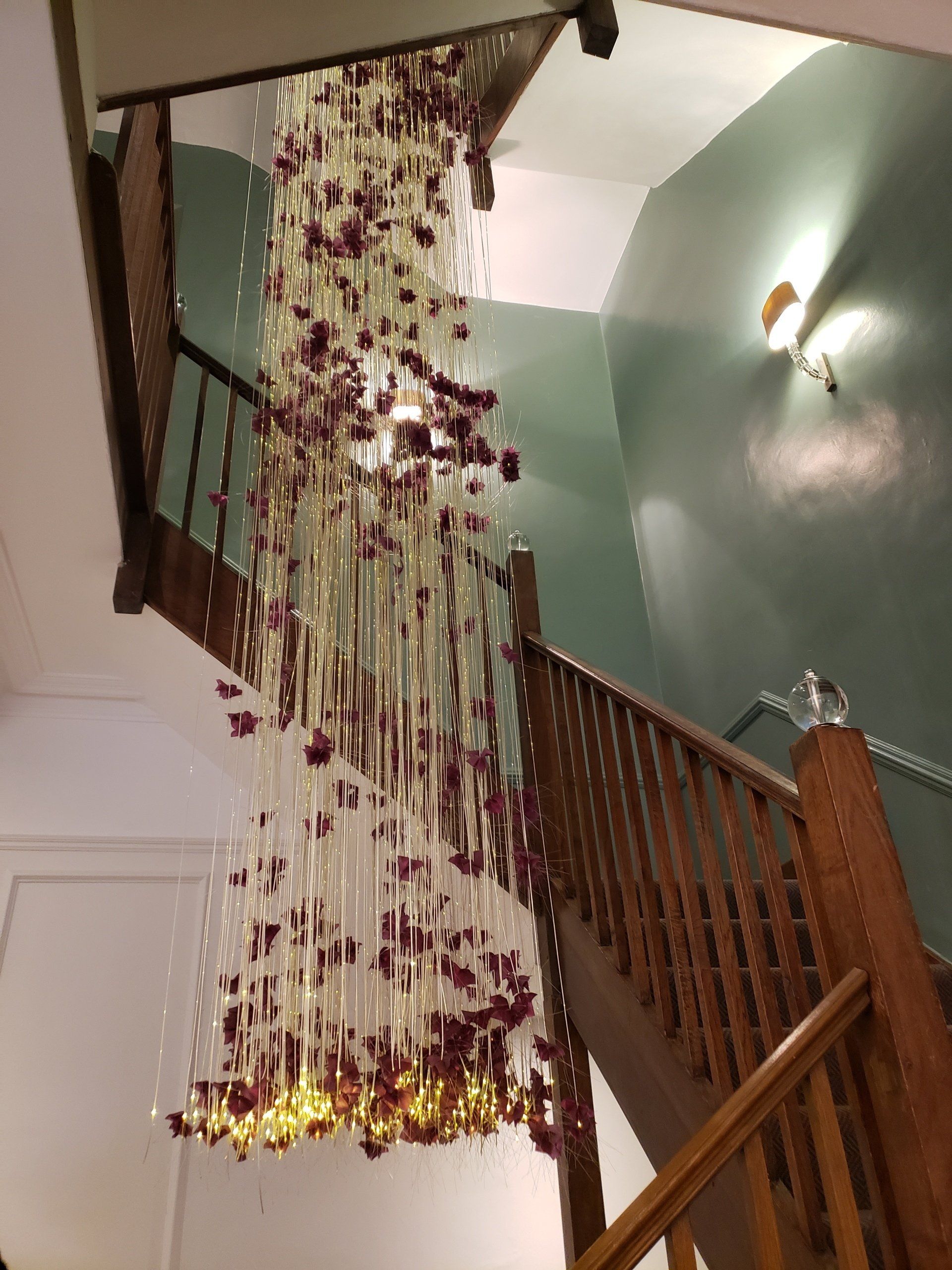 A staircase with a chandelier hanging from the ceiling