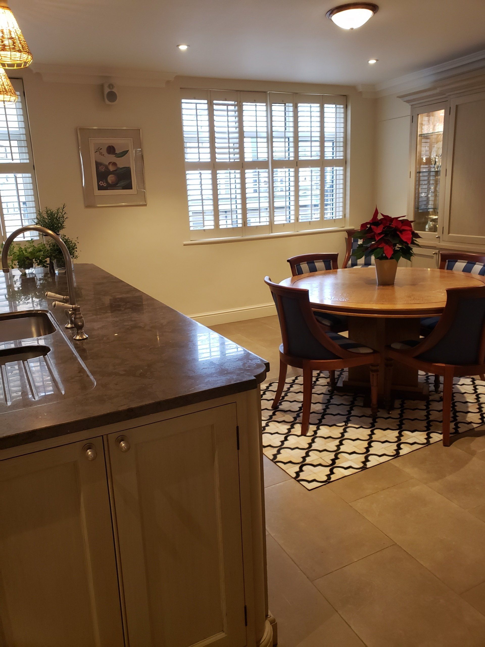 A kitchen with a table and chairs and a sink.