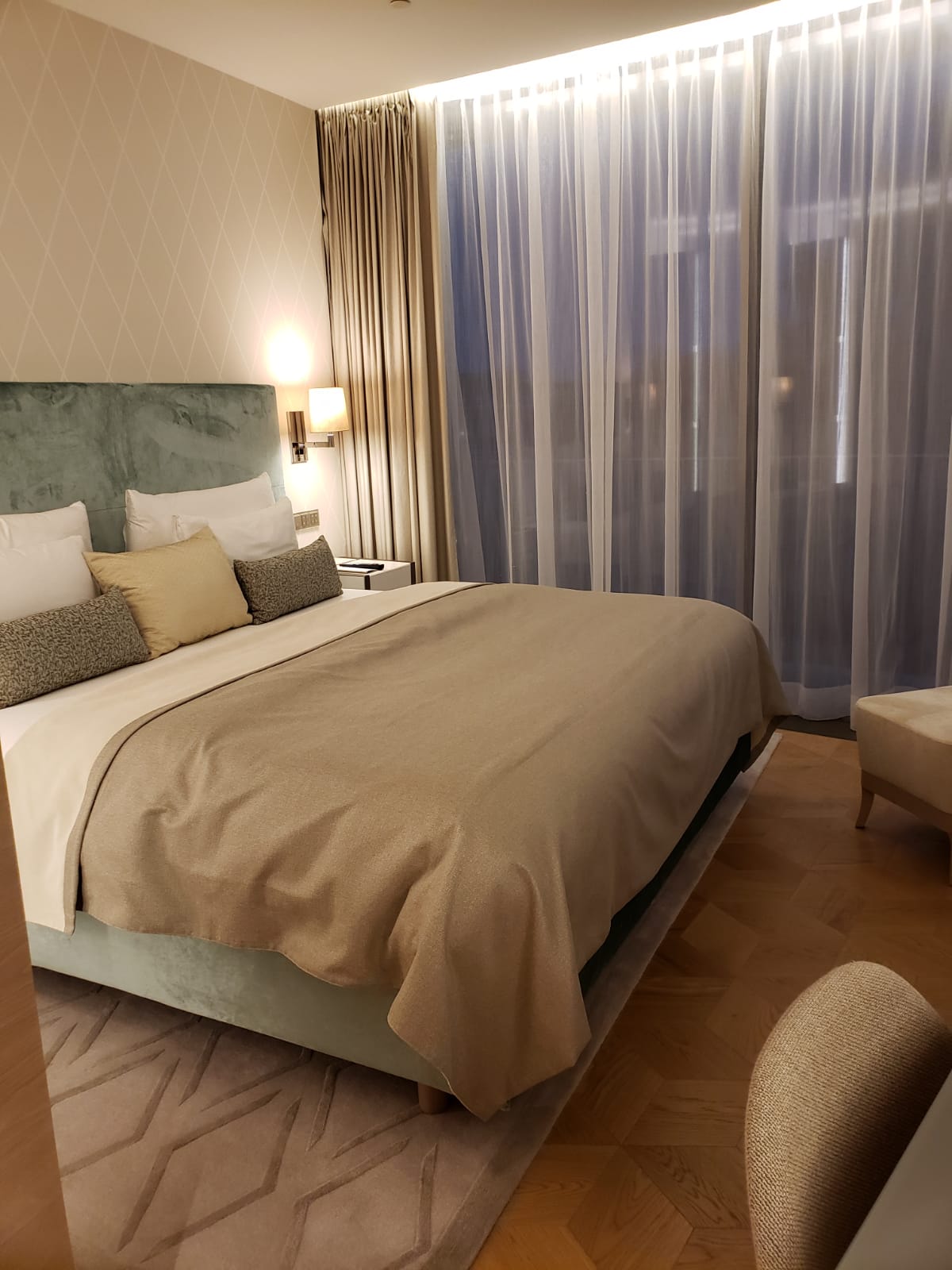 A hotel room with a large bed and a large window