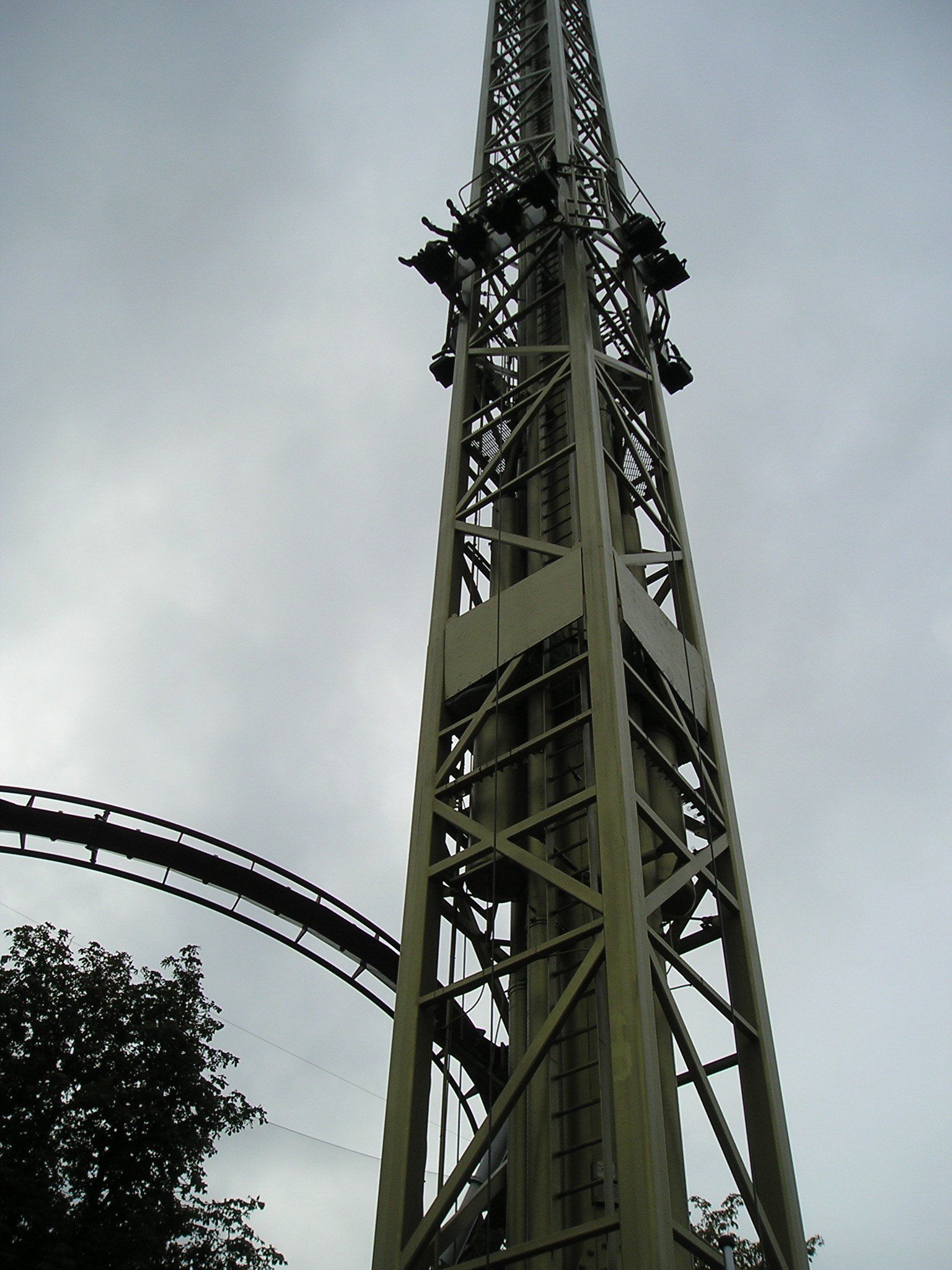 A very tall tower with a roller coaster in the background