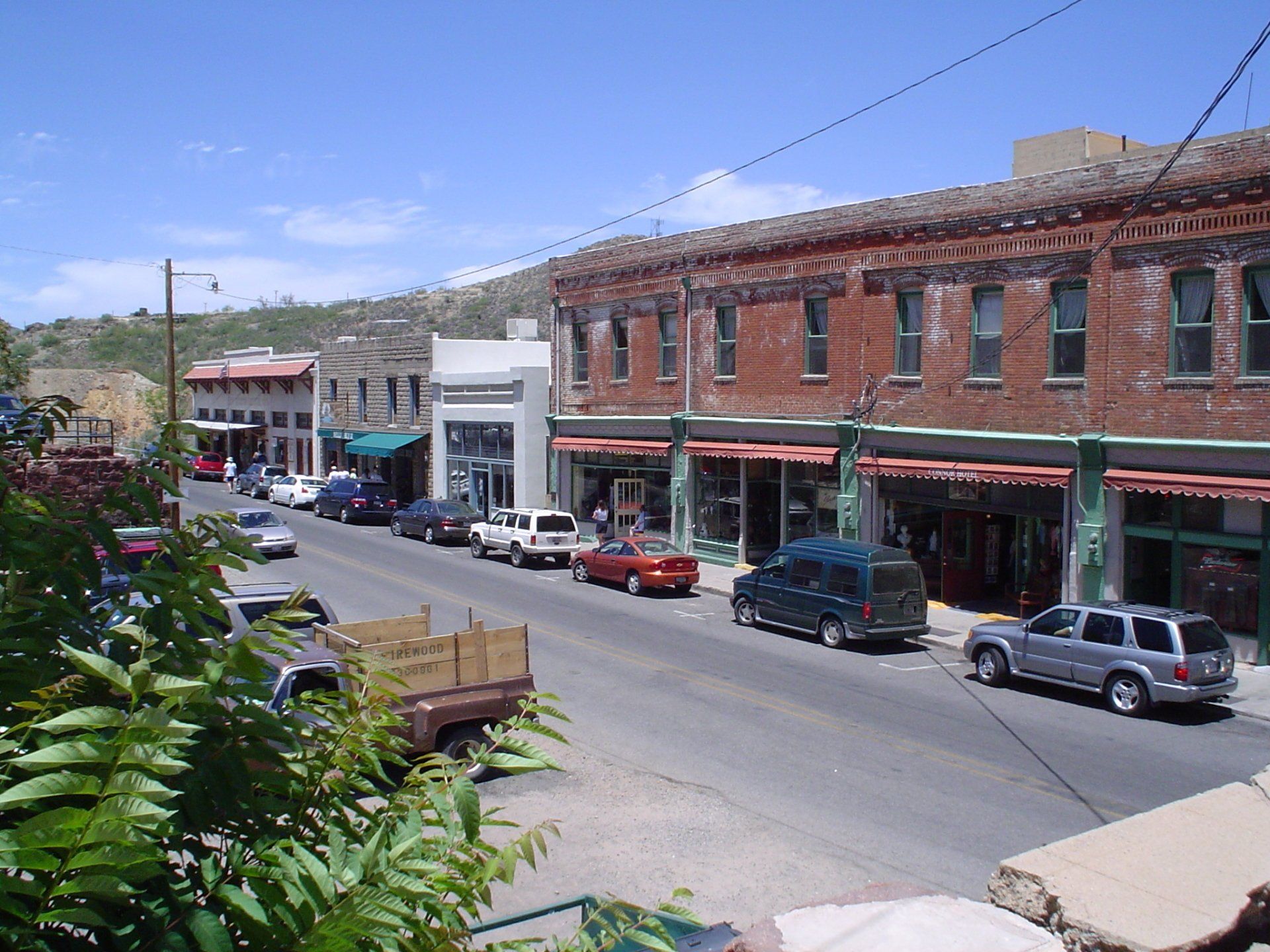 A row of cars are parked in front of a brick building