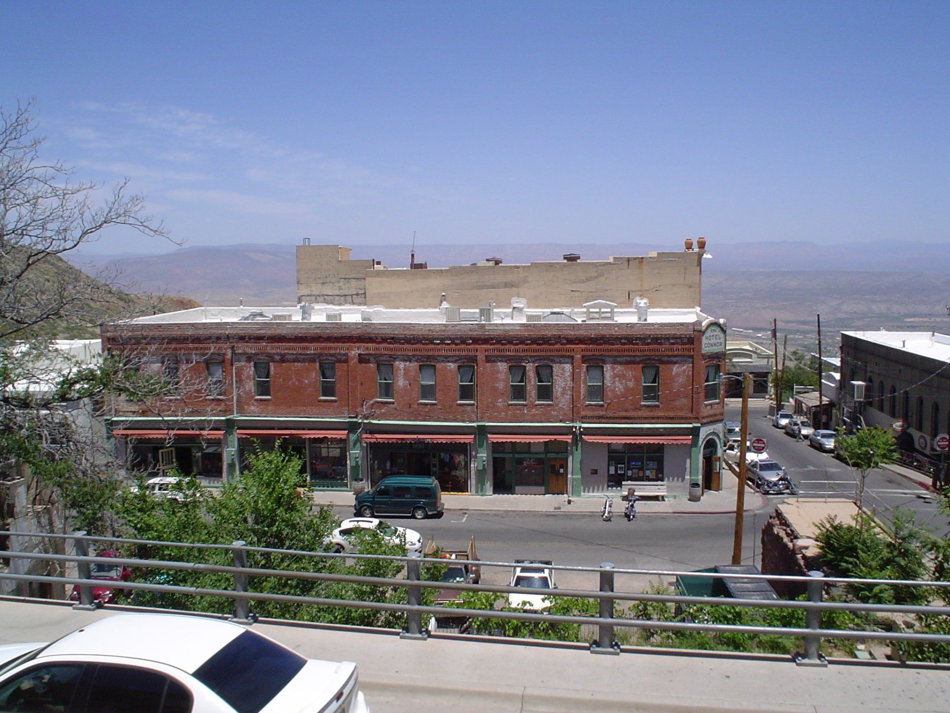 A white car is parked in front of a brick building