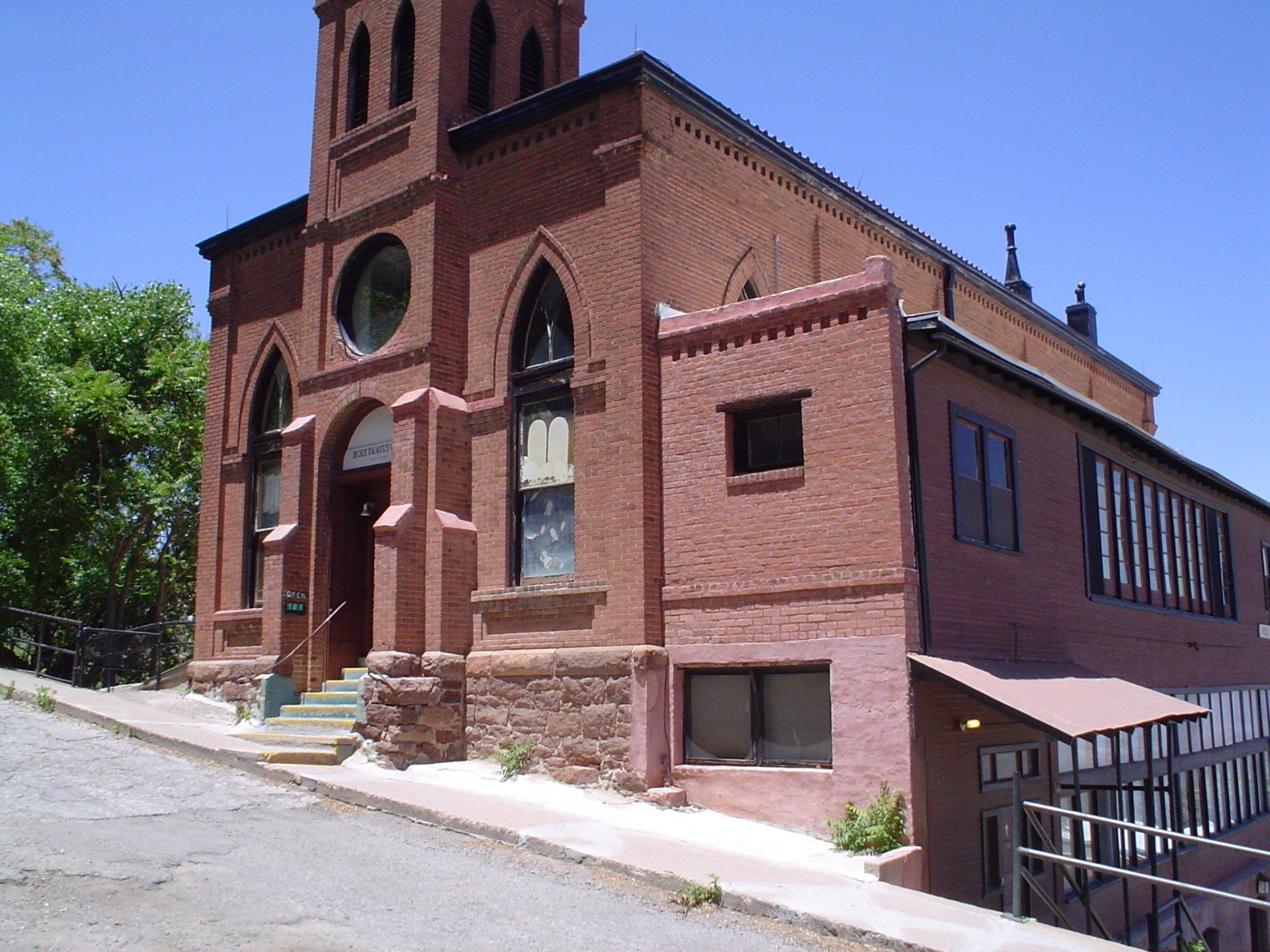 A large red brick building with a steep hill in front of it