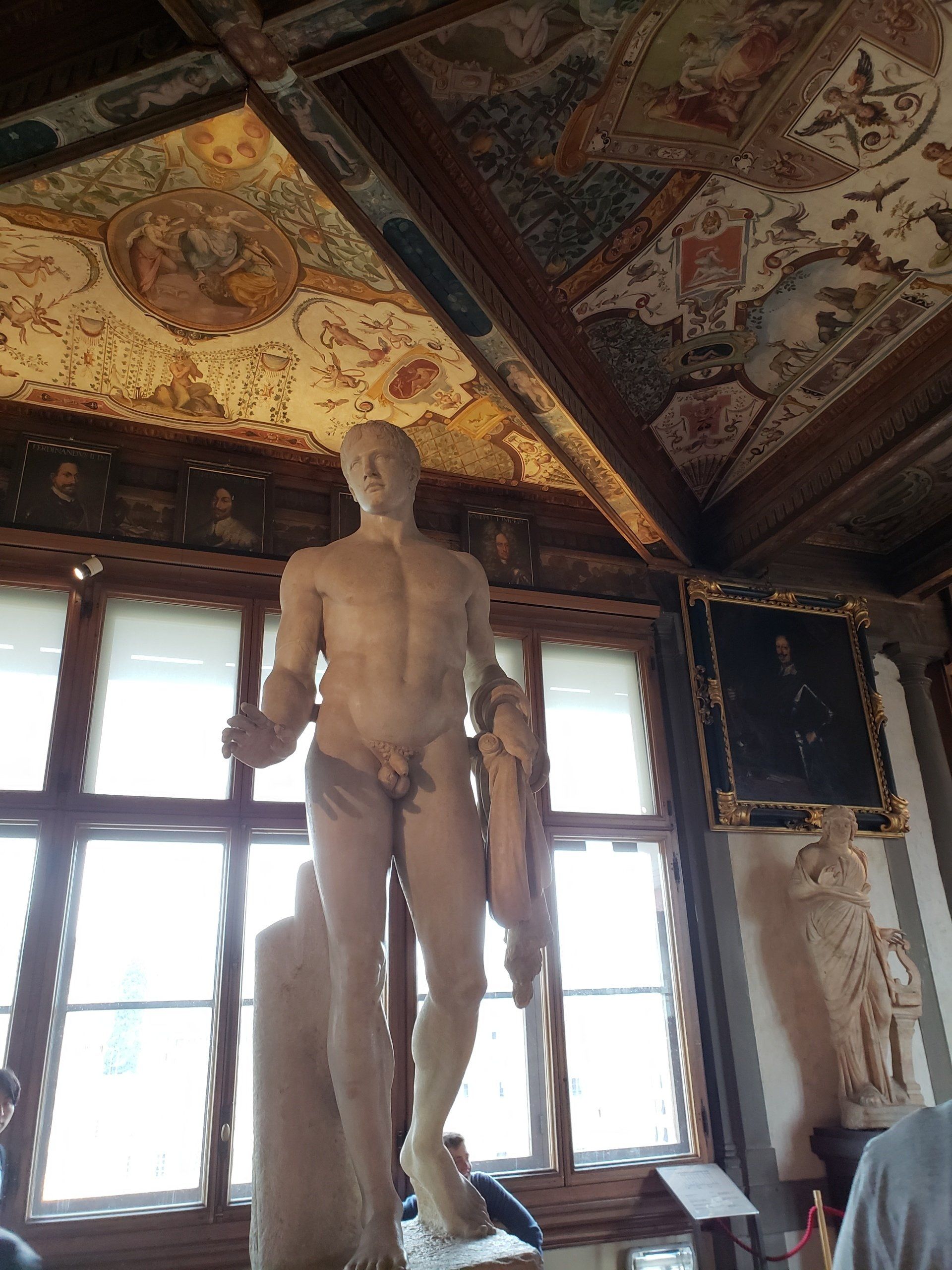 A statue of a man standing in front of a window in a room.