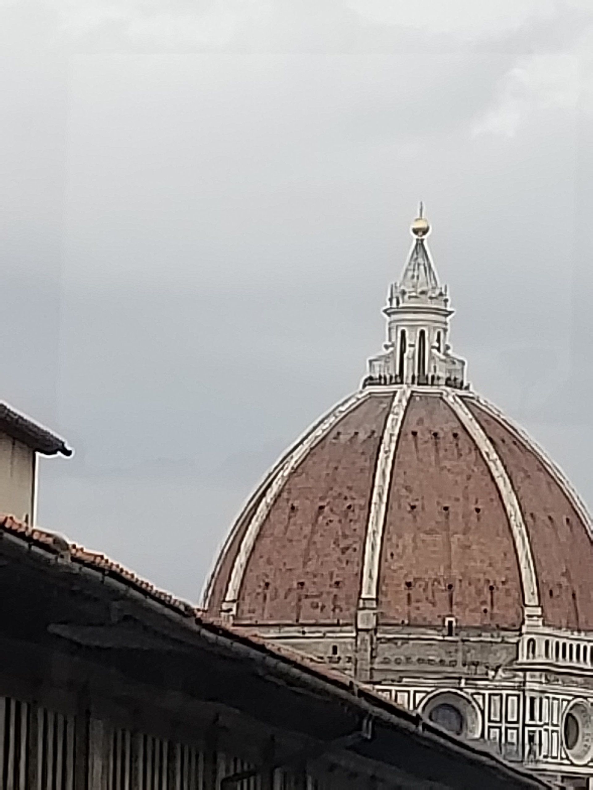 A large dome is sitting on top of a building with a cloudy sky in the background.