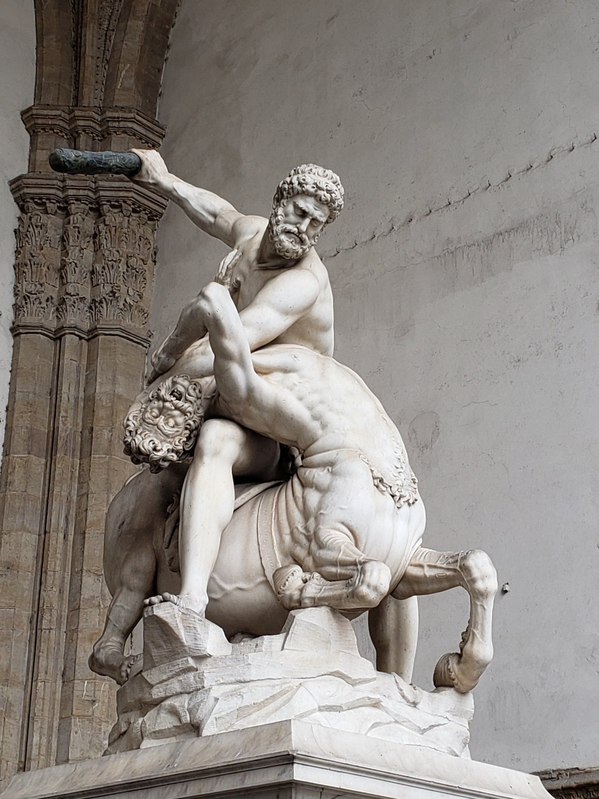 A statue of a man riding on the back of a bull.