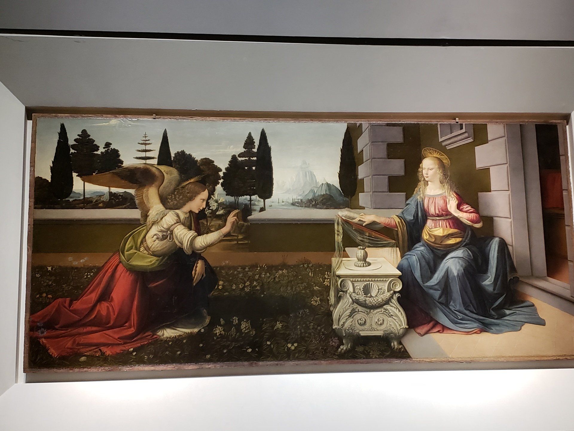 A painting of a woman kneeling down next to an angel