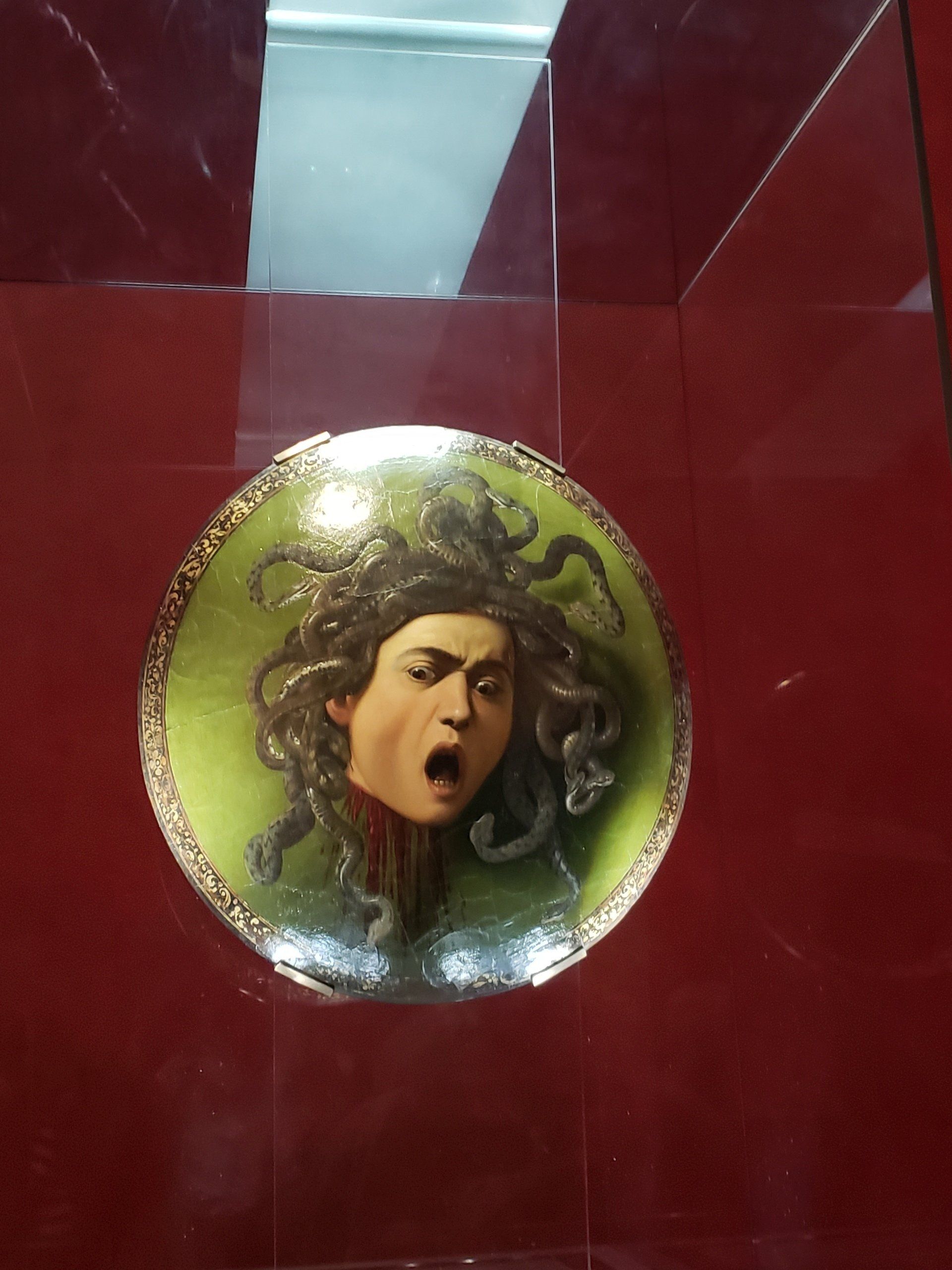 A painting of a woman with a snake on her head