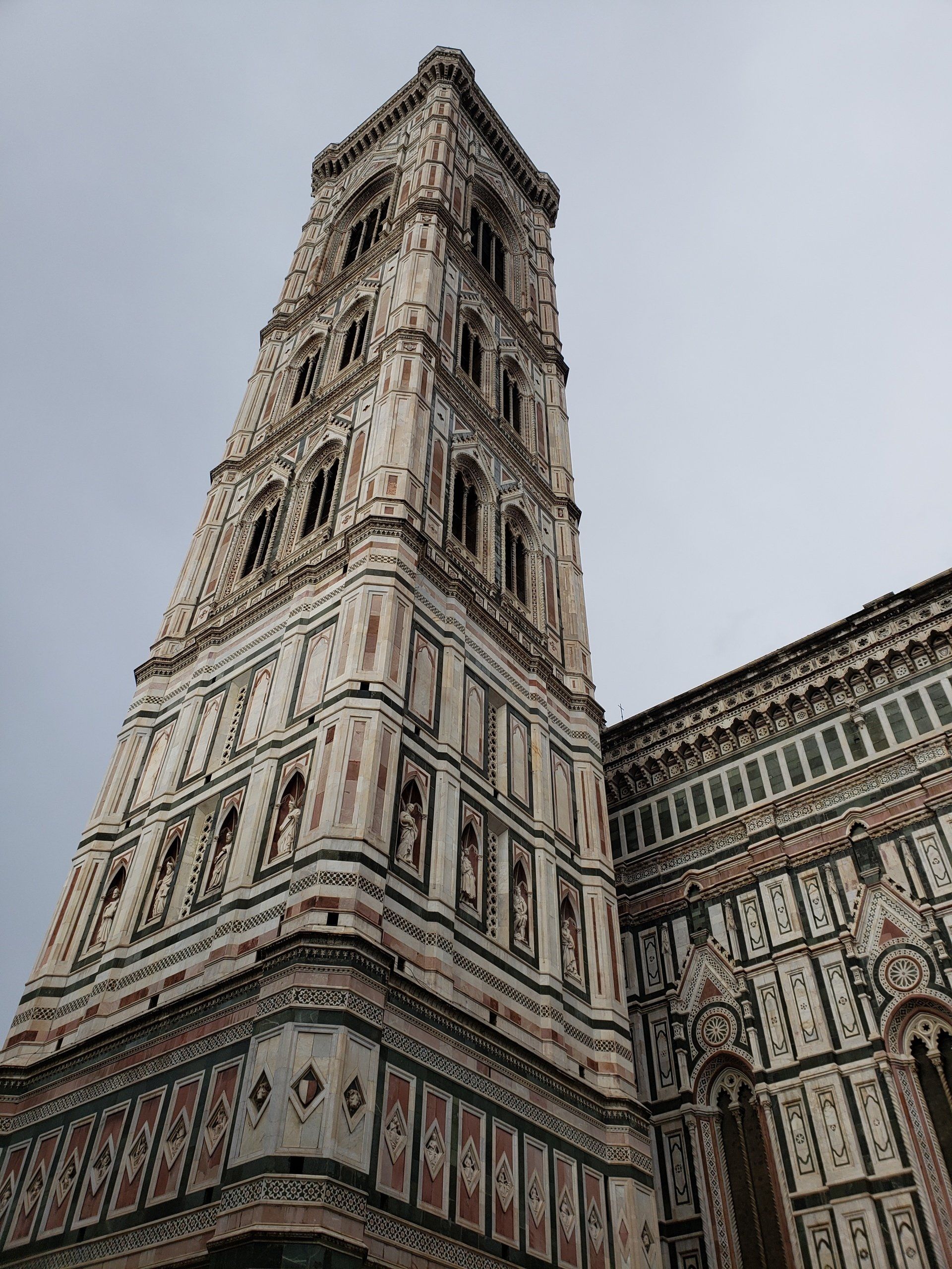 Looking up at a very tall building with a bell tower.