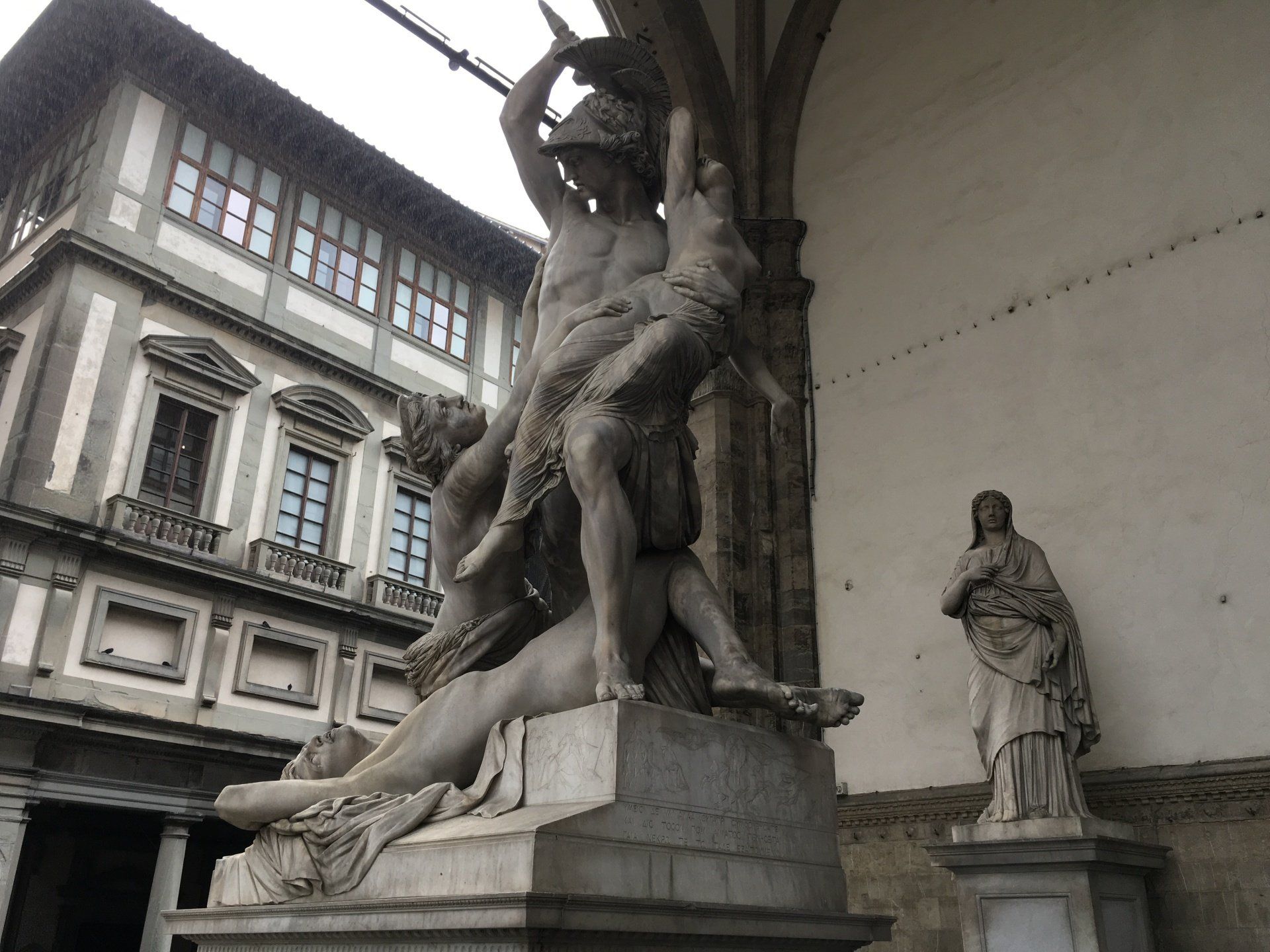 A statue of a man and a woman standing in front of a building