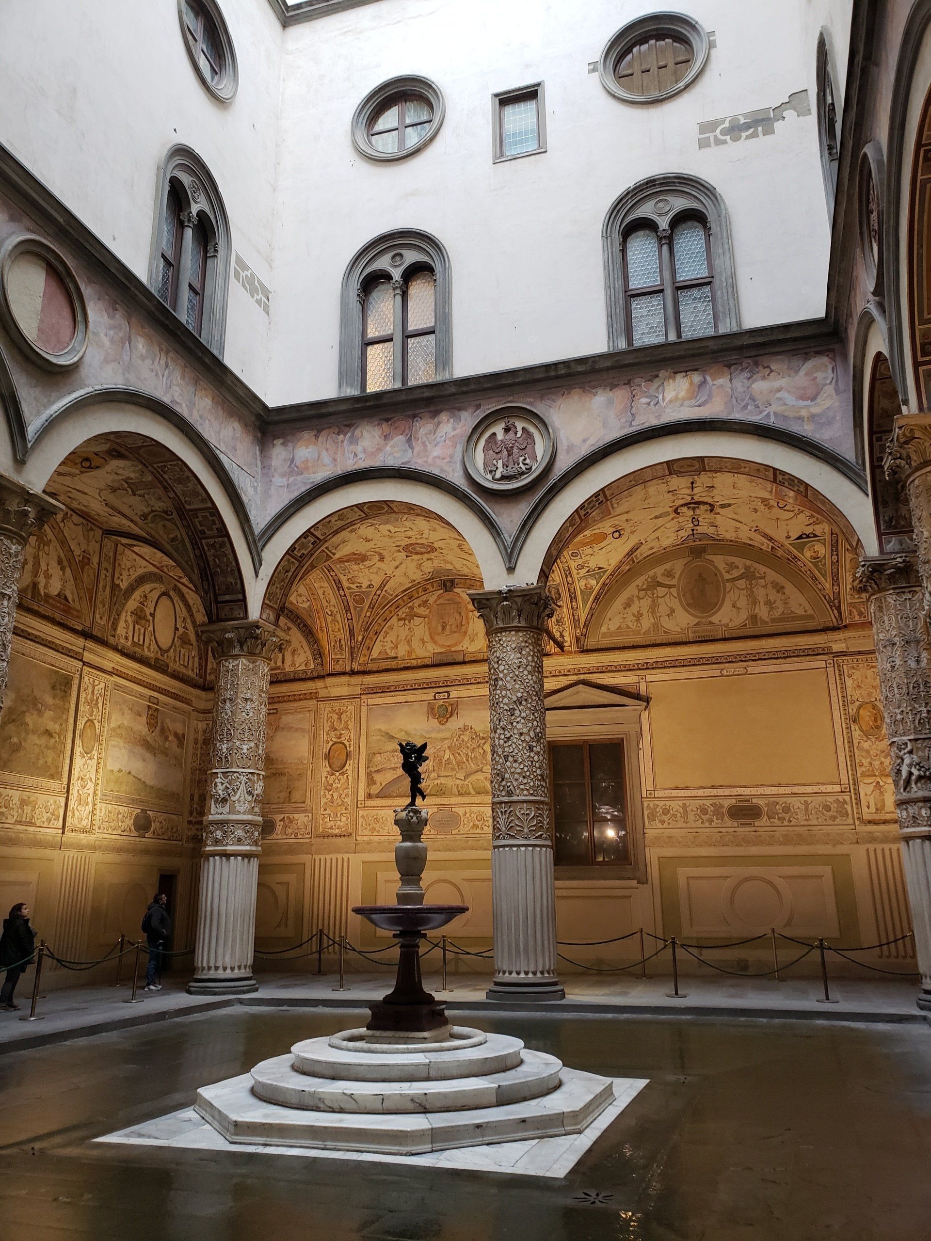 There is a fountain in the middle of the courtyard of a building.