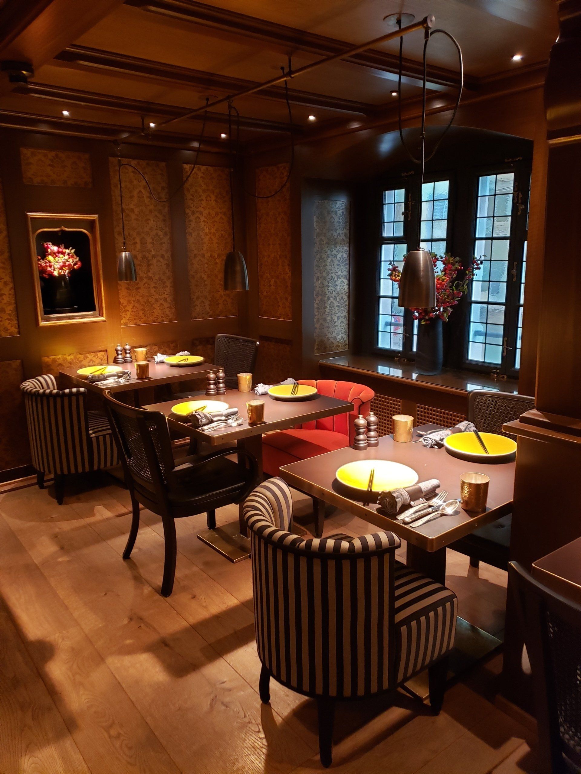 A restaurant with tables and chairs and plates on them