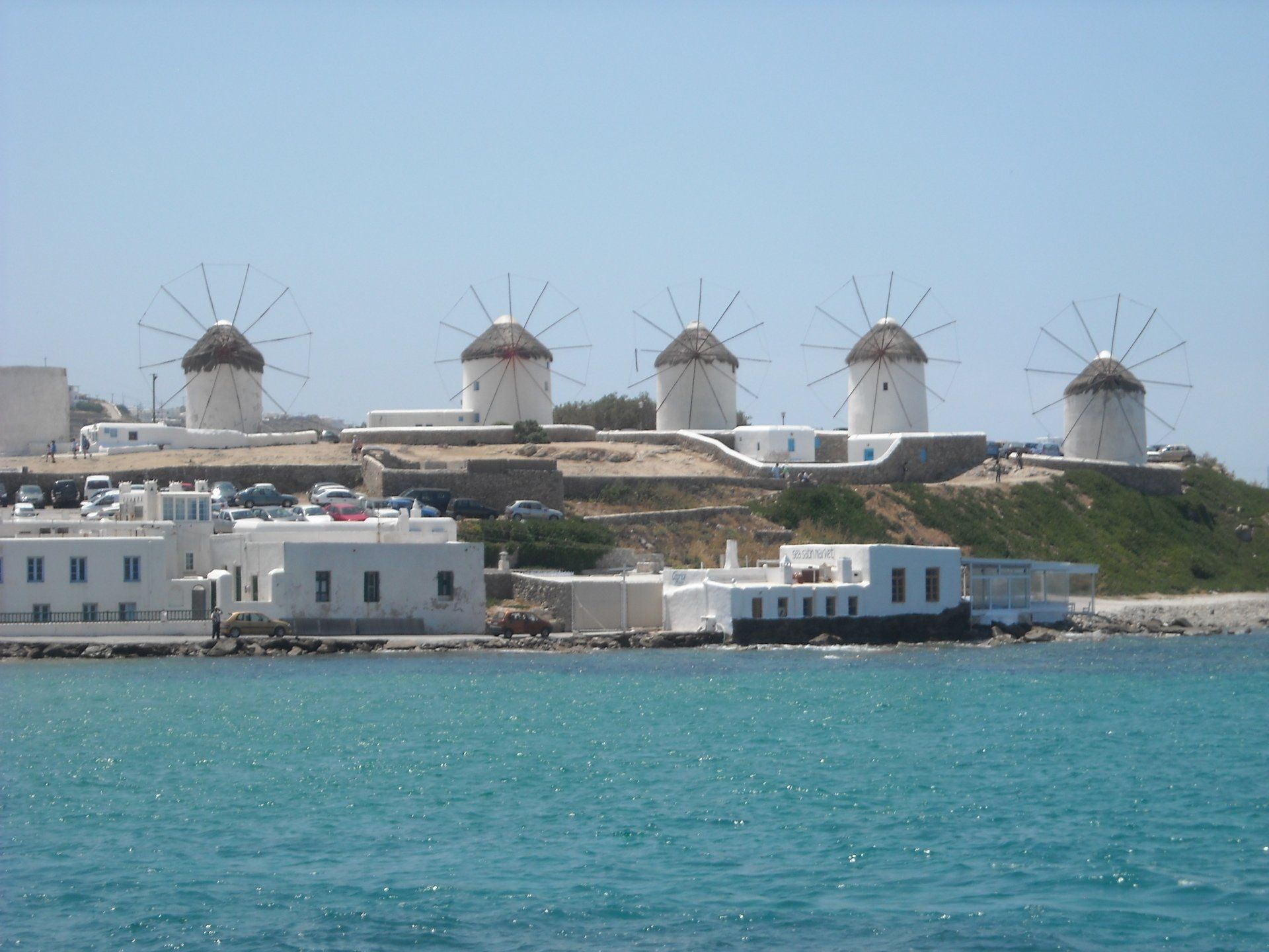 A group of windmills sitting on top of a hill overlooking the ocean