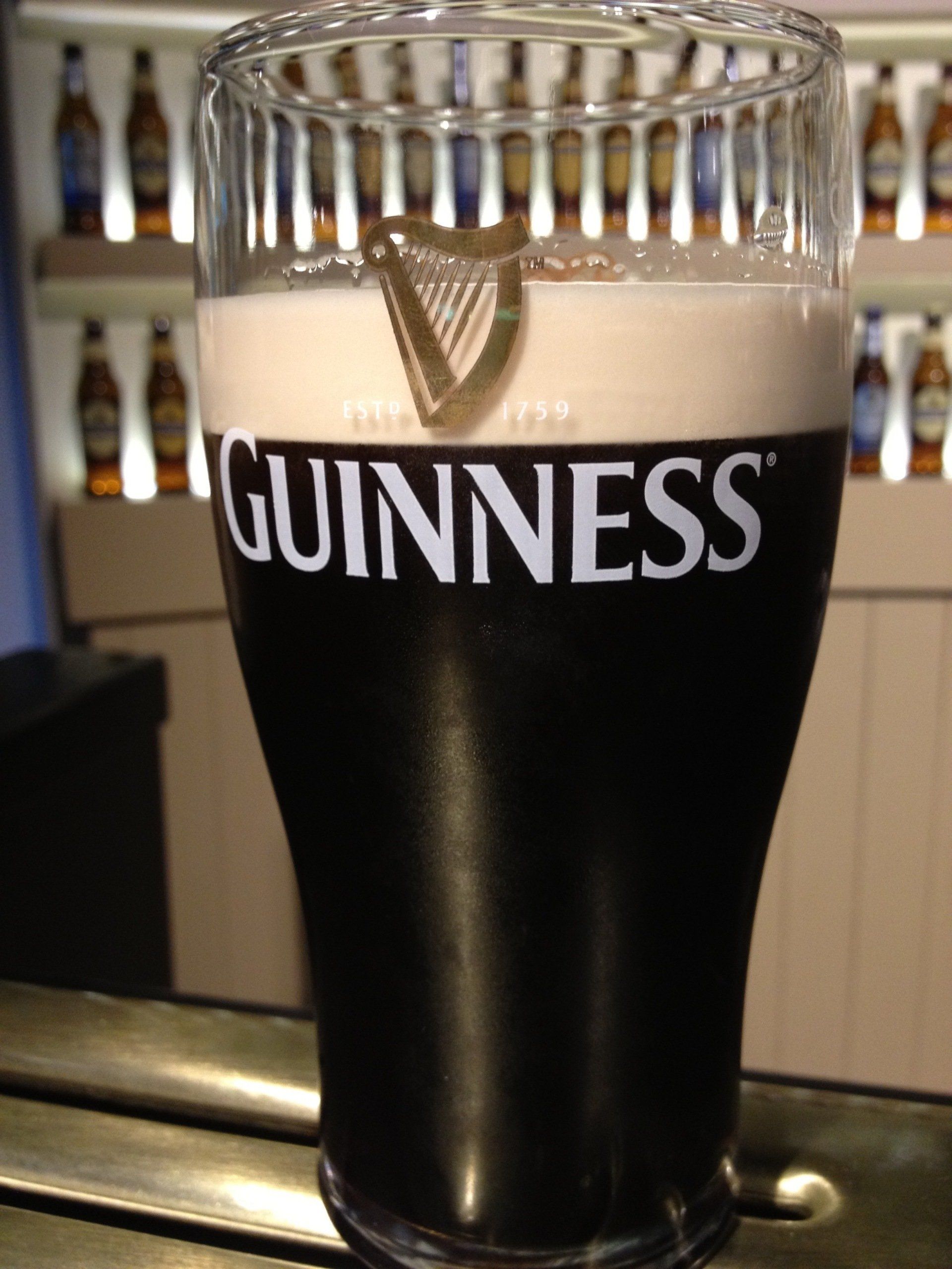 A glass of guinness sits on a bar