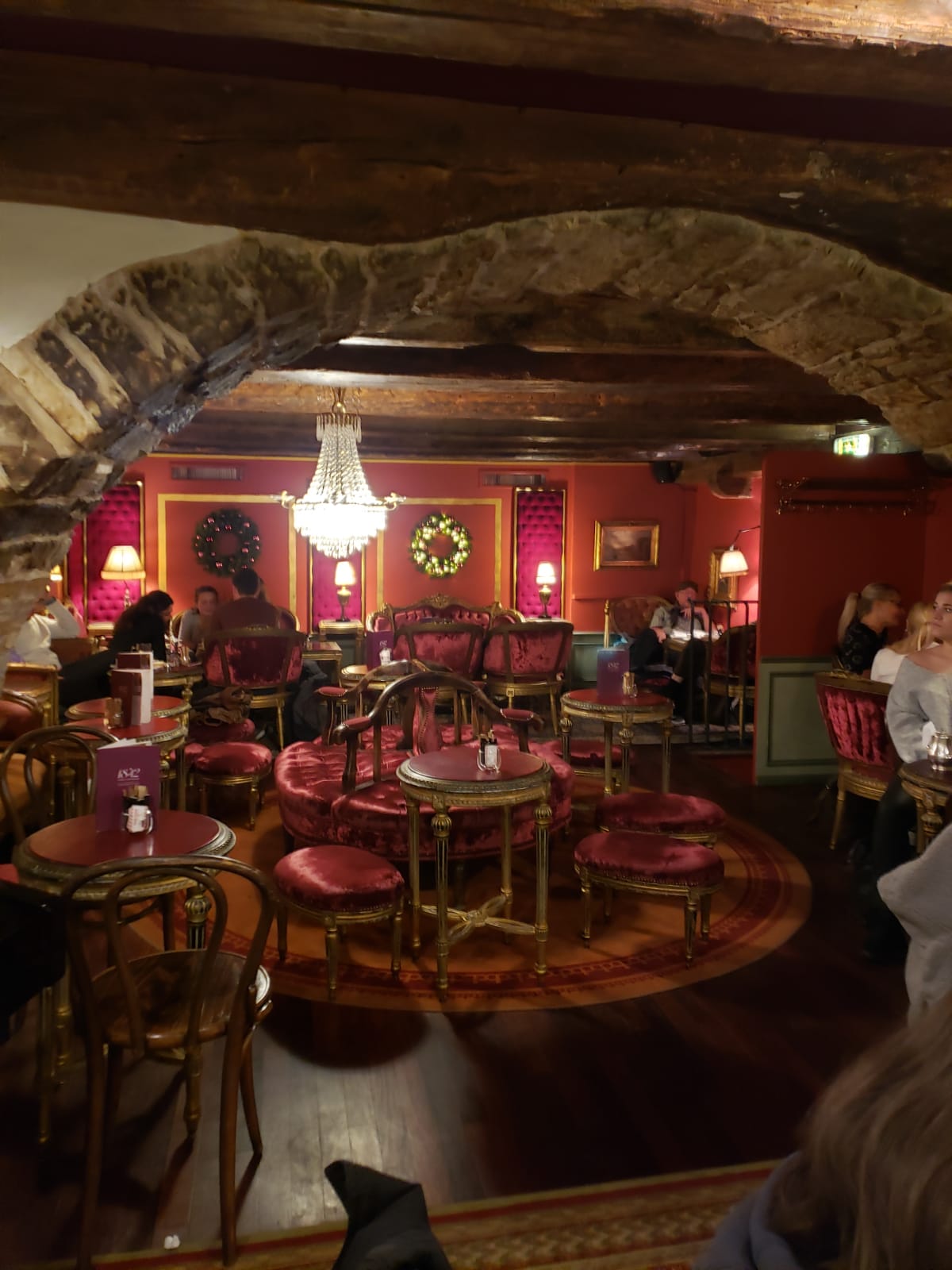 A restaurant with tables and chairs and a wreath on the wall