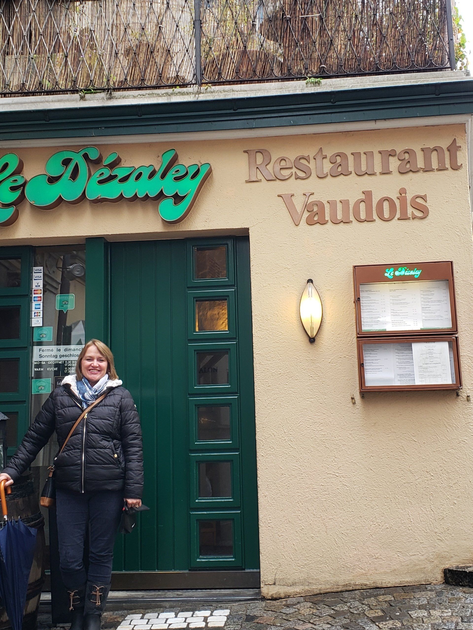 A woman is standing in front of the restaurant vaudois