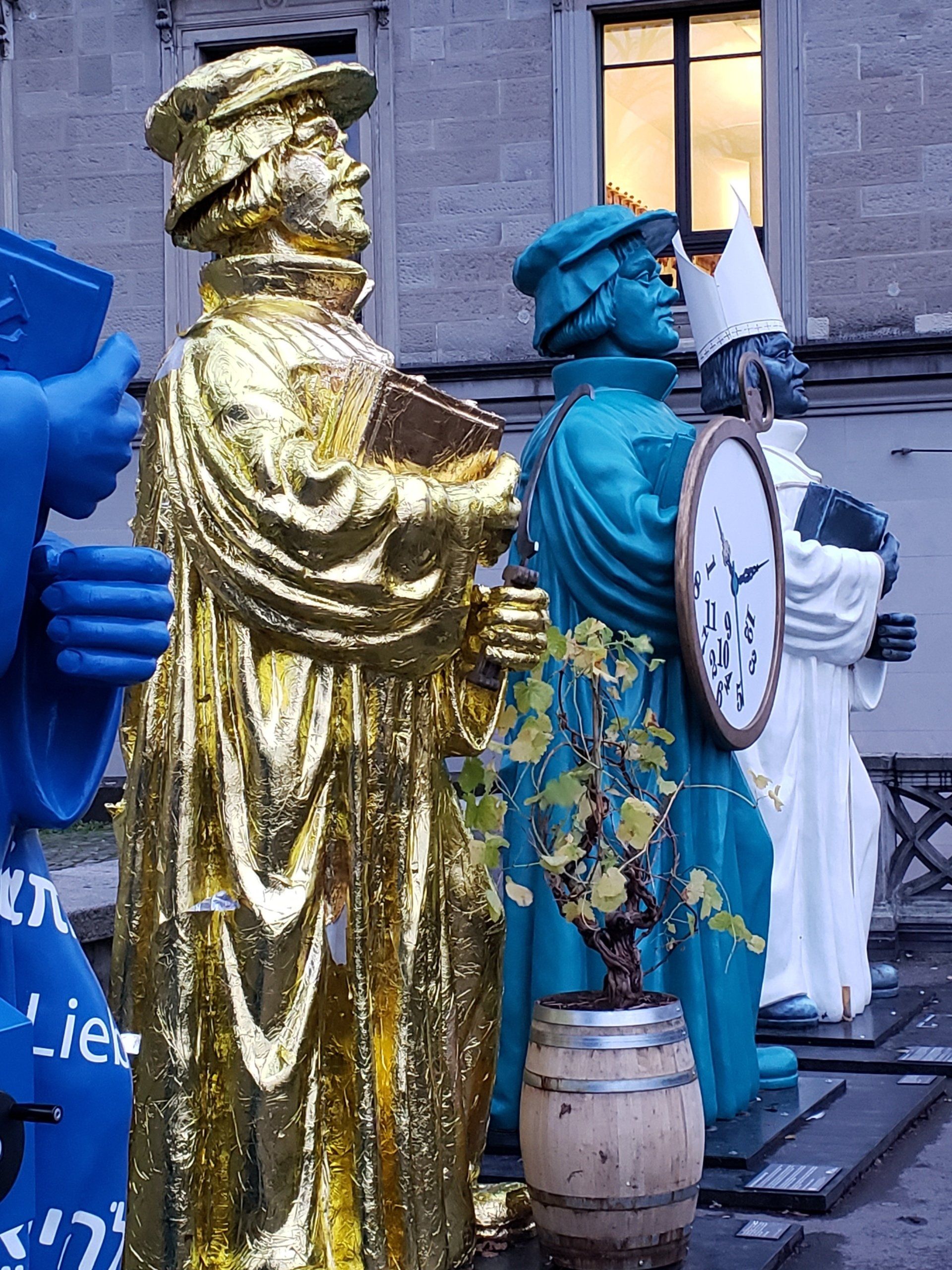 A statue of a man holding a book and a clock