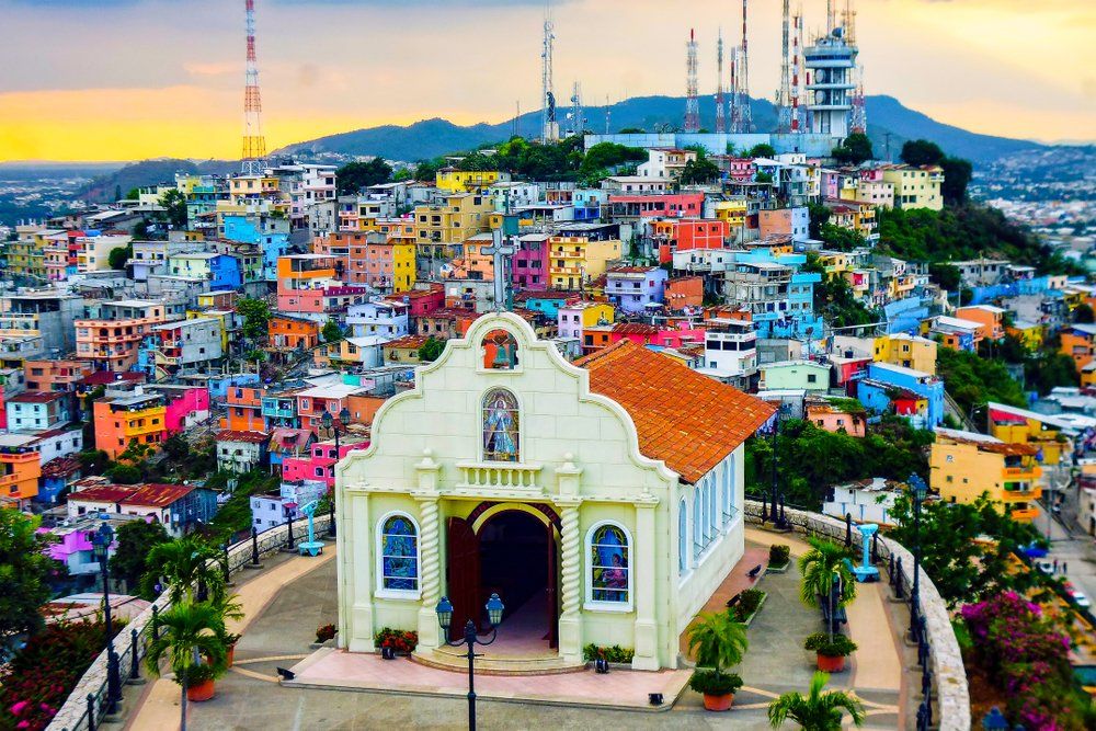 An aerial view of a colorful city with a church in the foreground.