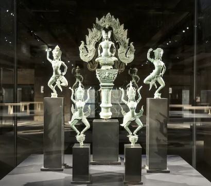 A group of statues are displayed in a glass case