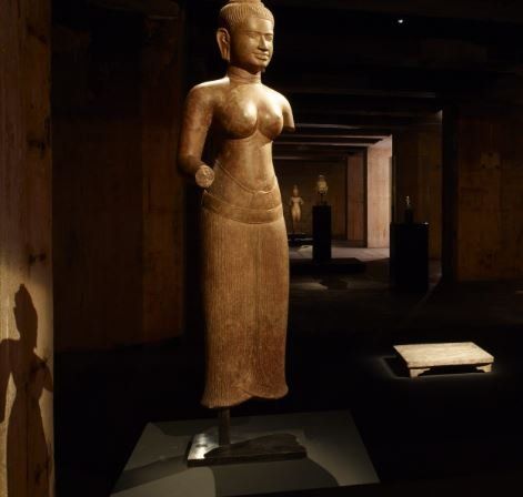 A statue of a woman standing in a dark room