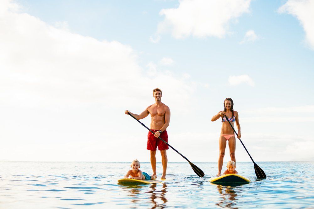 A family is paddle boarding in the ocean.