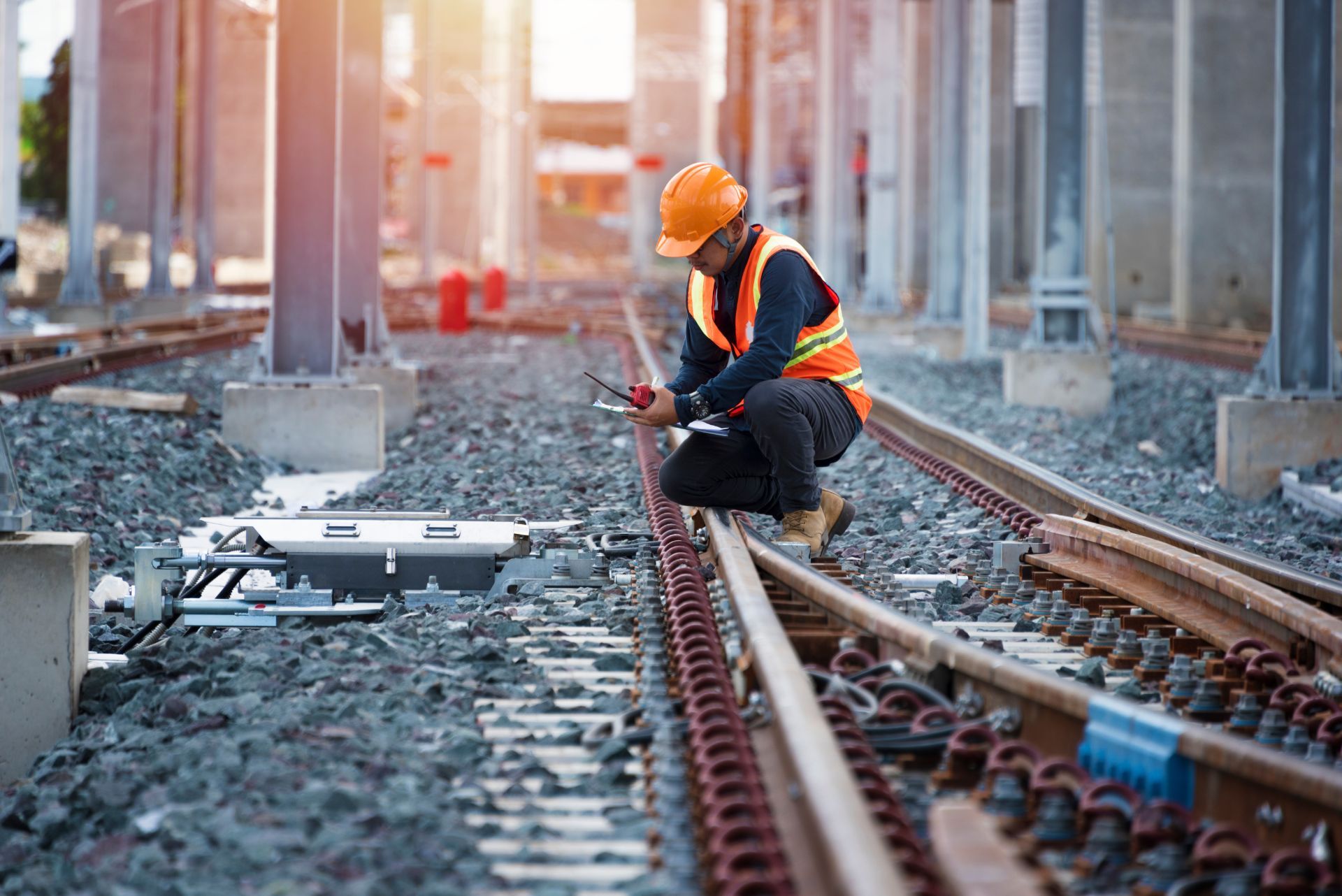worker kneeling on railway