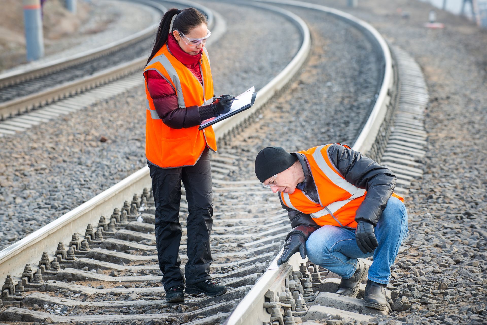 two workers inspecting track rail