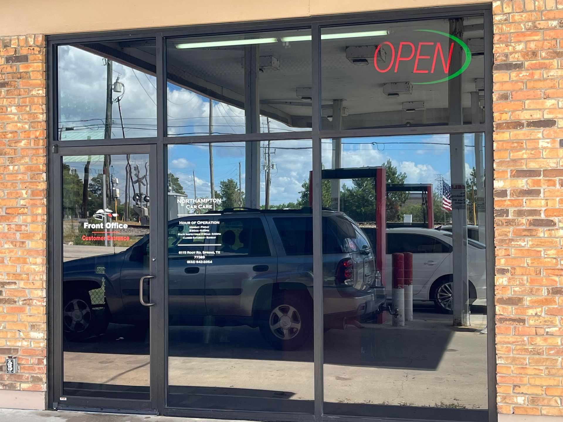 Storefront with large glass windows, reflecting a car wash and 