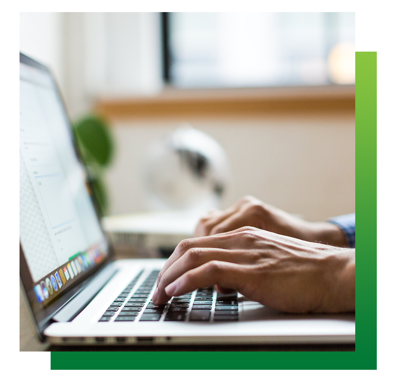 Person typing on laptop, hands on keyboard, indoors near a window.