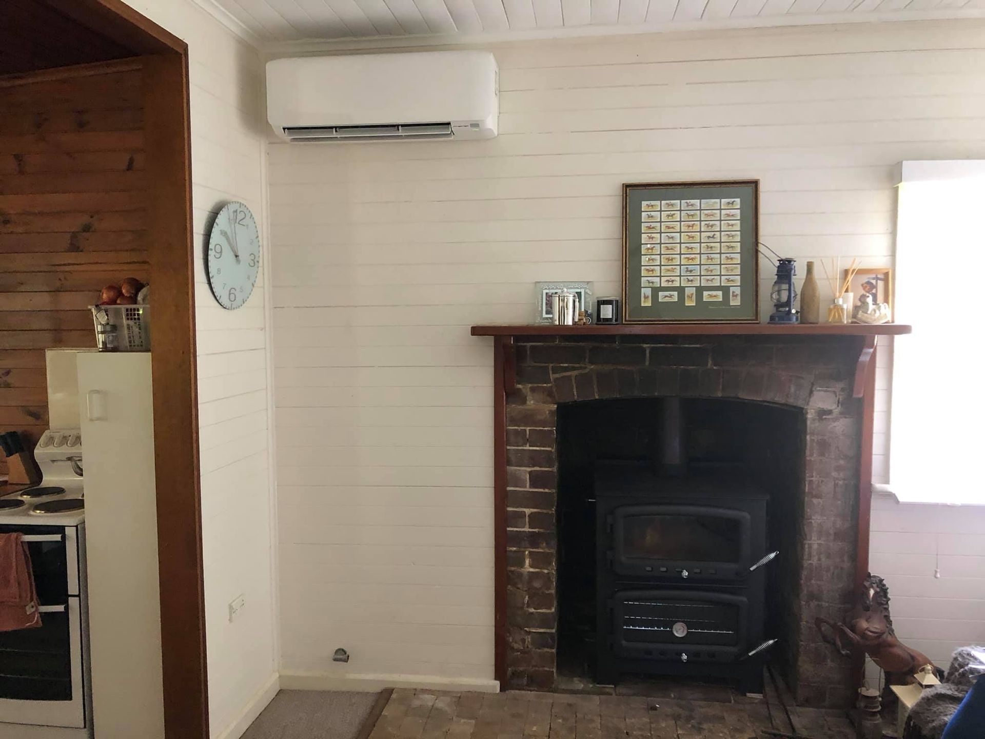 A Living Room With a Fireplace and a Clock on the Wall — Steve's Air Conditioning in Lakeside Dr, NSW