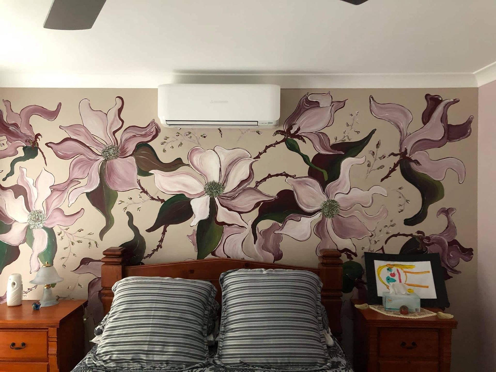 A Bedroom With a Bed and a Painting of Flowers on the Wall — Steve's Air Conditioning in Lakeside Dr, NSW