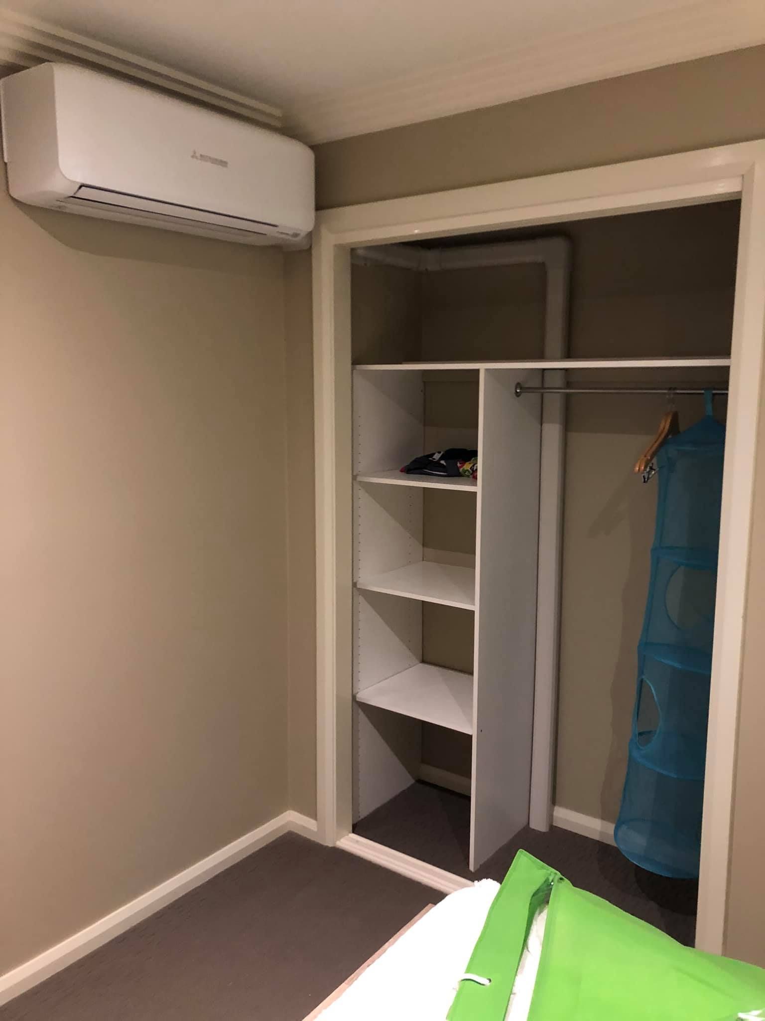 A Bedroom With a Bed, Closet, and Air Conditioner — Steve's Air Conditioning in Lakeside Dr, NSW
