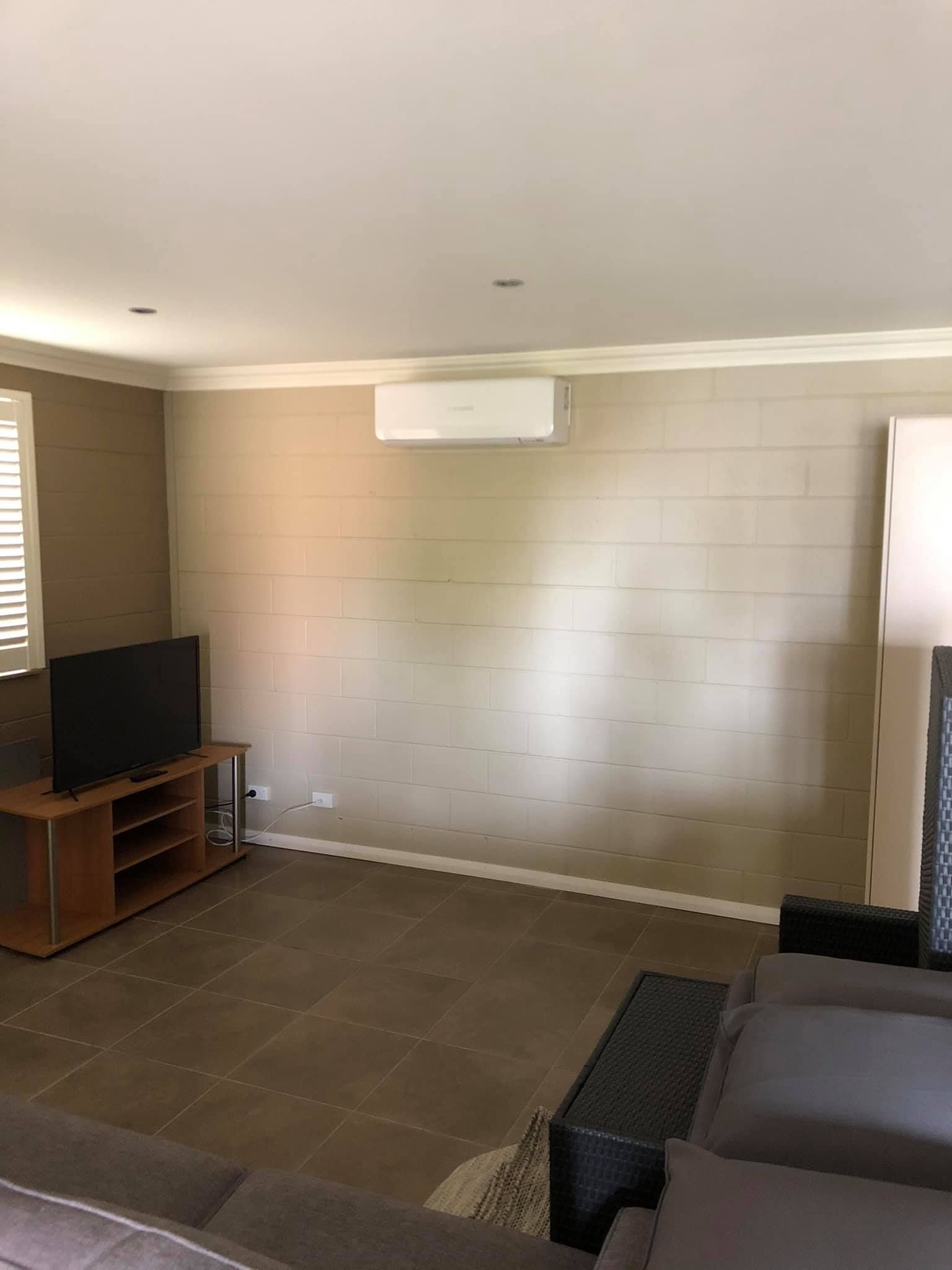 A Living Room With a Couch, Television, and Air Conditioner — Steve's Air Conditioning in Lakeside Dr, NSW